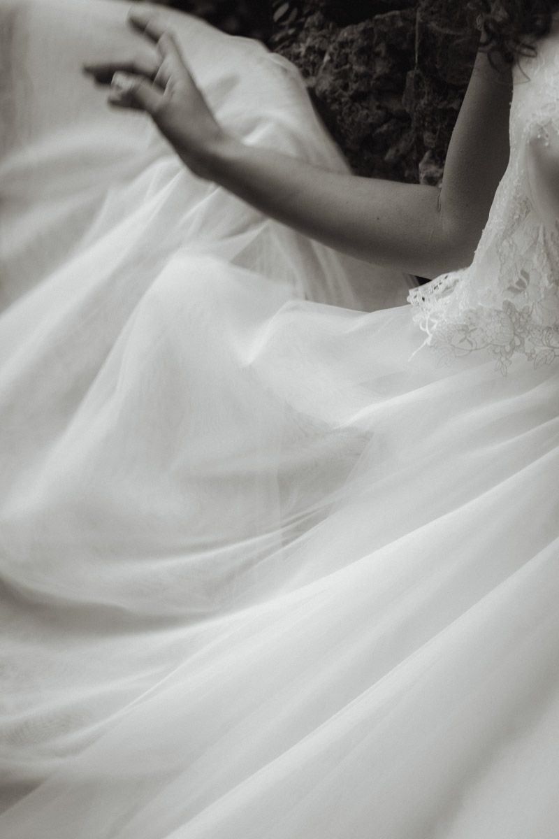 Close-up details of a white wedding gown's flowing fabric and delicate layers.