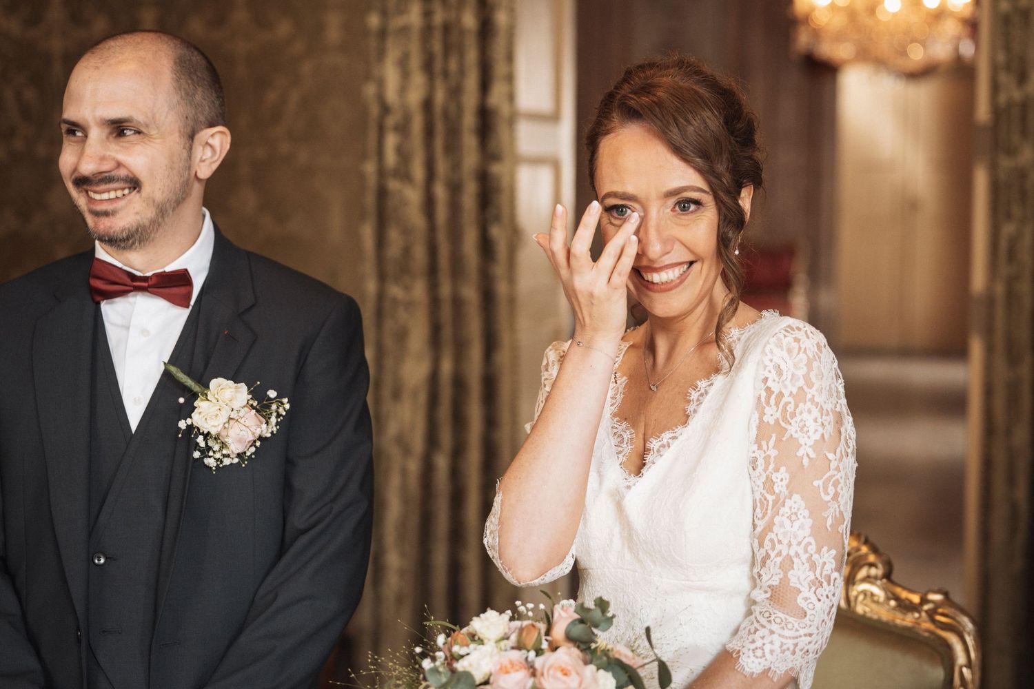 Couple sharing intimate moments in an elegant venue with chandelier lighting.