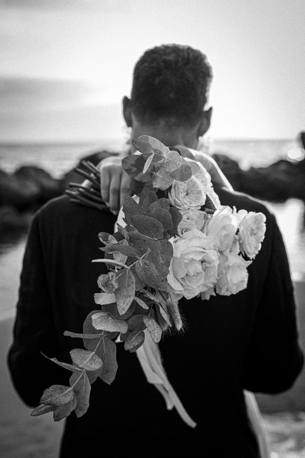 Black and white images of white flowers being held against a dark background.