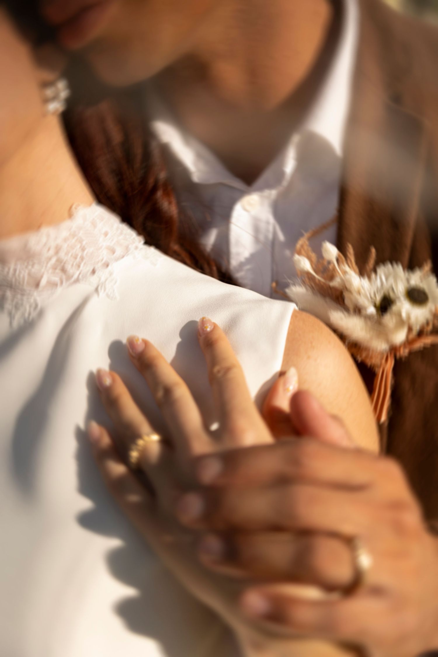 Close-up sequence of hands gently holding and releasing delicate white flower petals in warm lighting.