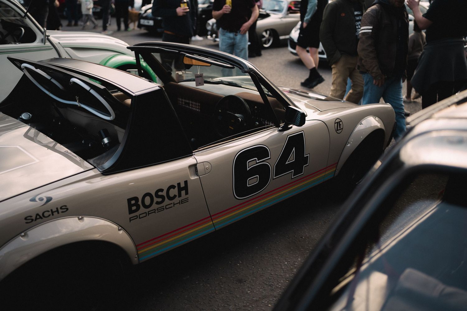 Vintage Porsche 911 race car number 64 with Bosch livery at a classic car show.