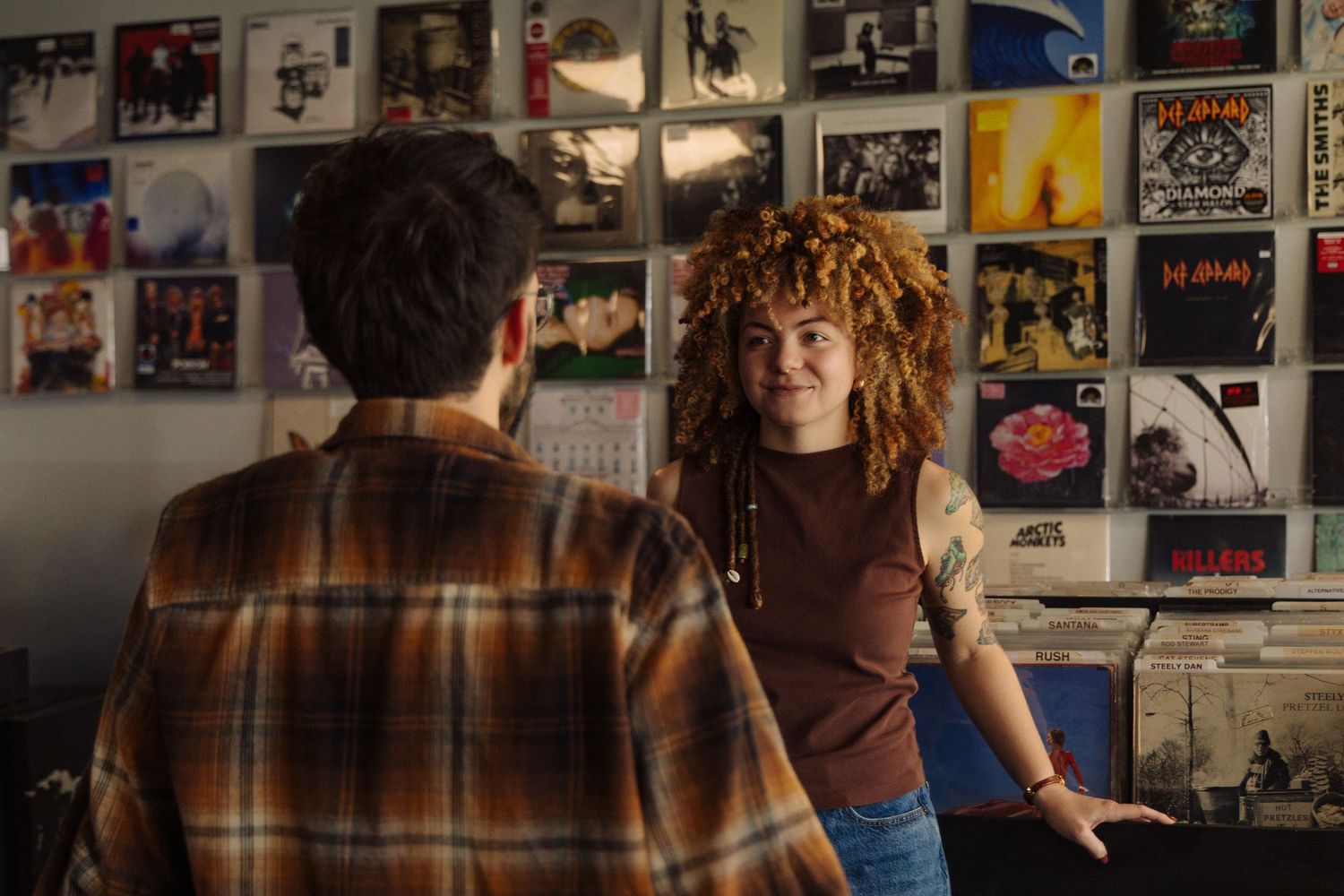 A collage of blurry photos and posters arranged on a wall creates an artistic display with warm lighting.