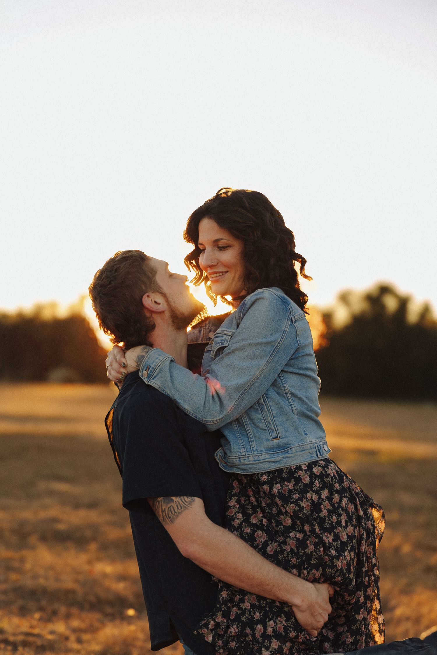 Couple embracing during golden hour sunset in romantic outdoor photo series.