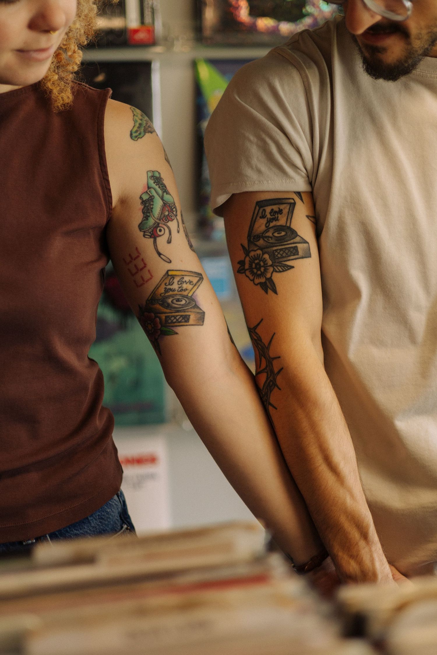 Close-up view of tattooed arms resting on a counter or table surface.