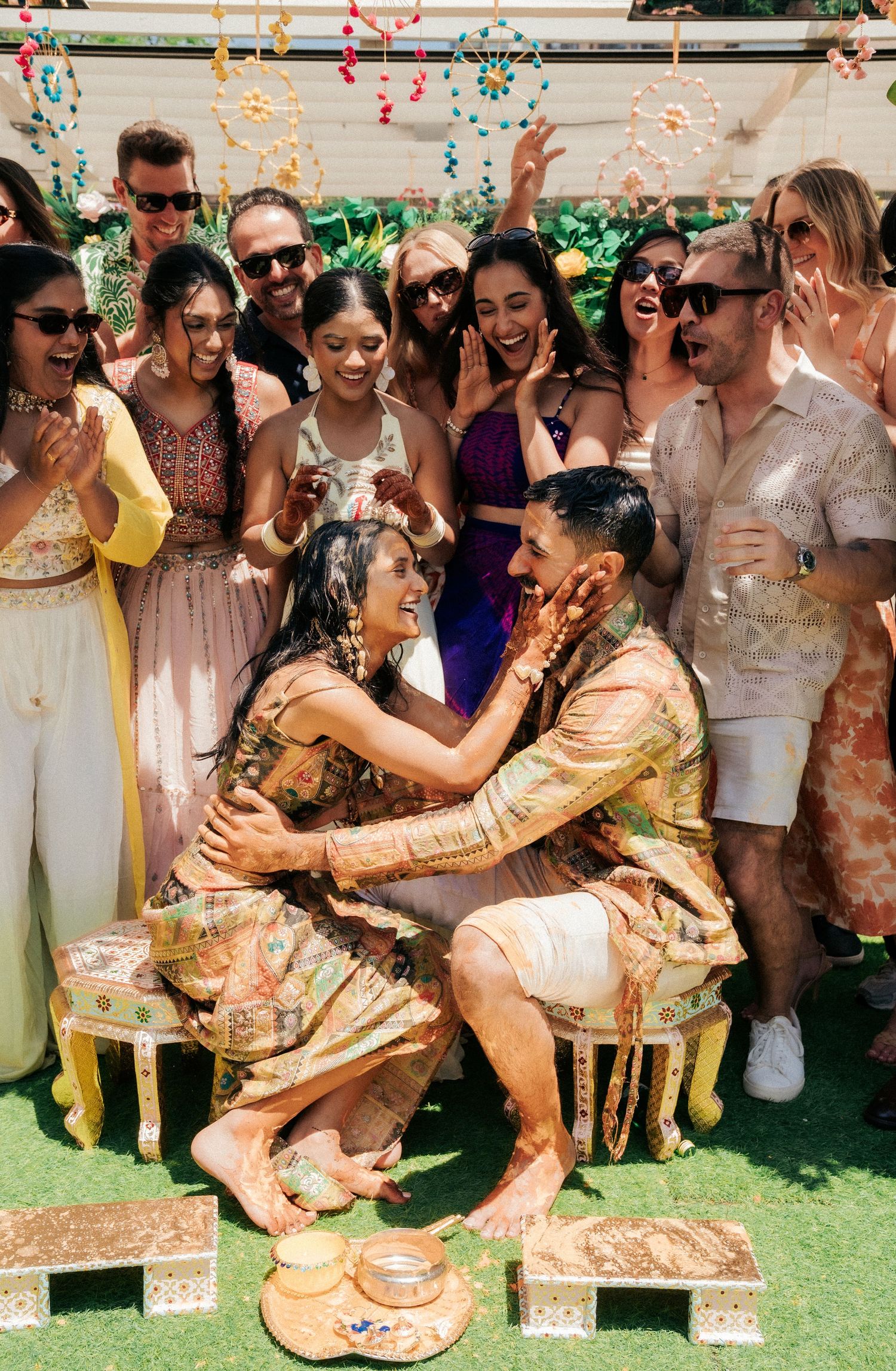 People celebrate at an outdoor party with confetti and festive decorations on a sunny day.