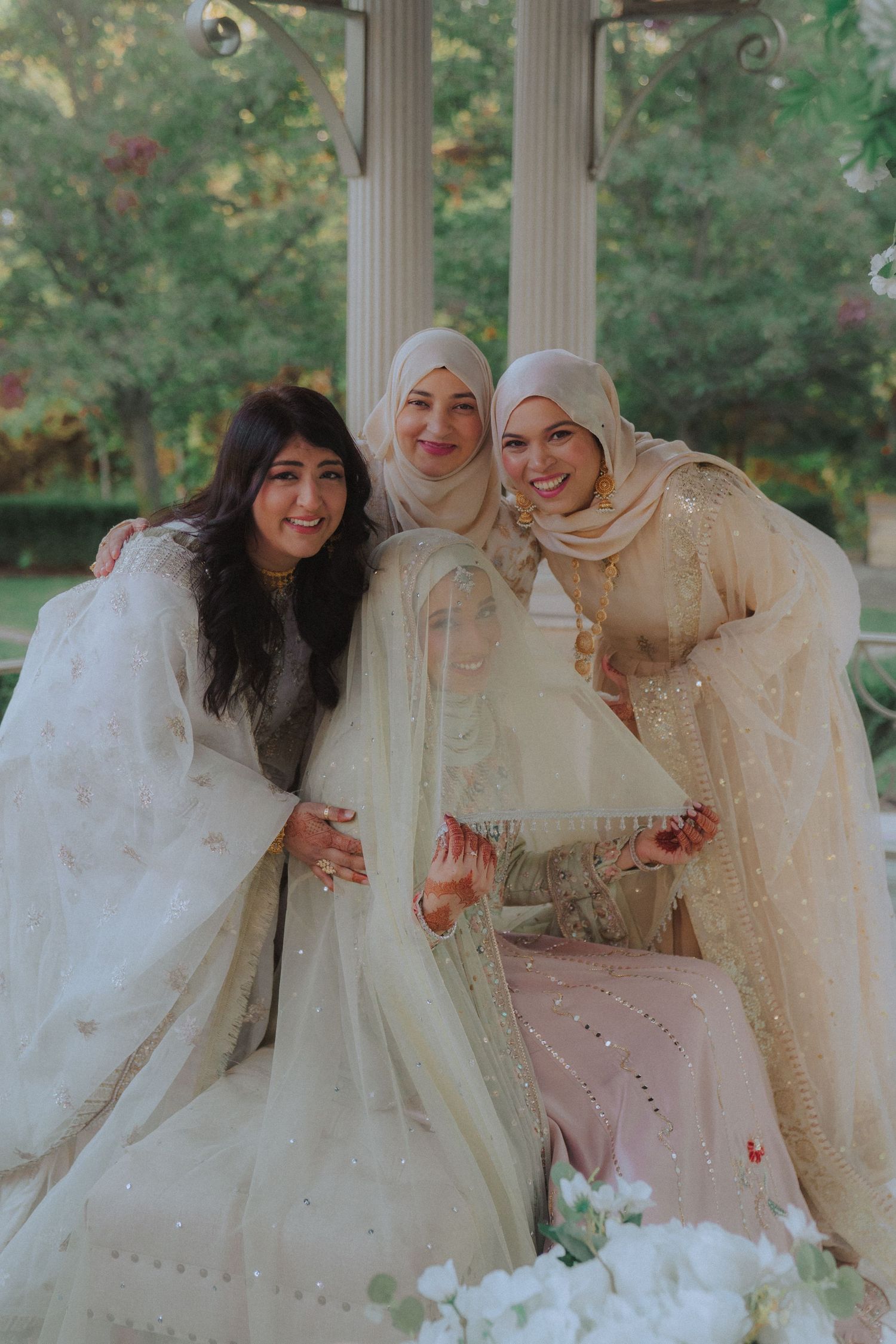 Group photo of people wearing elegant white and cream formal attire.