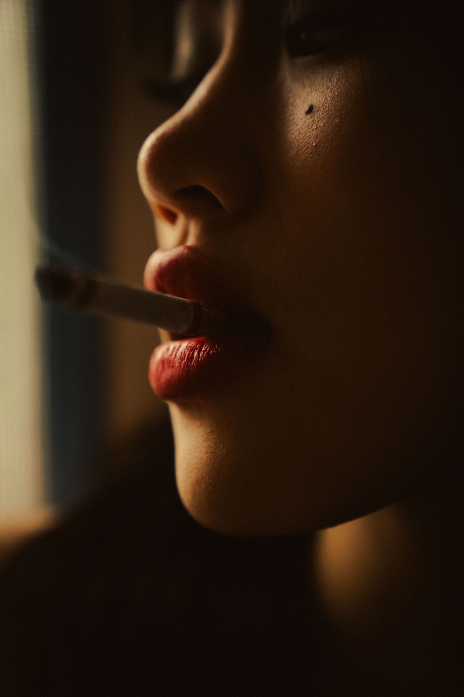 Close-up artistic shots of red lips in dramatic lighting and shadows.