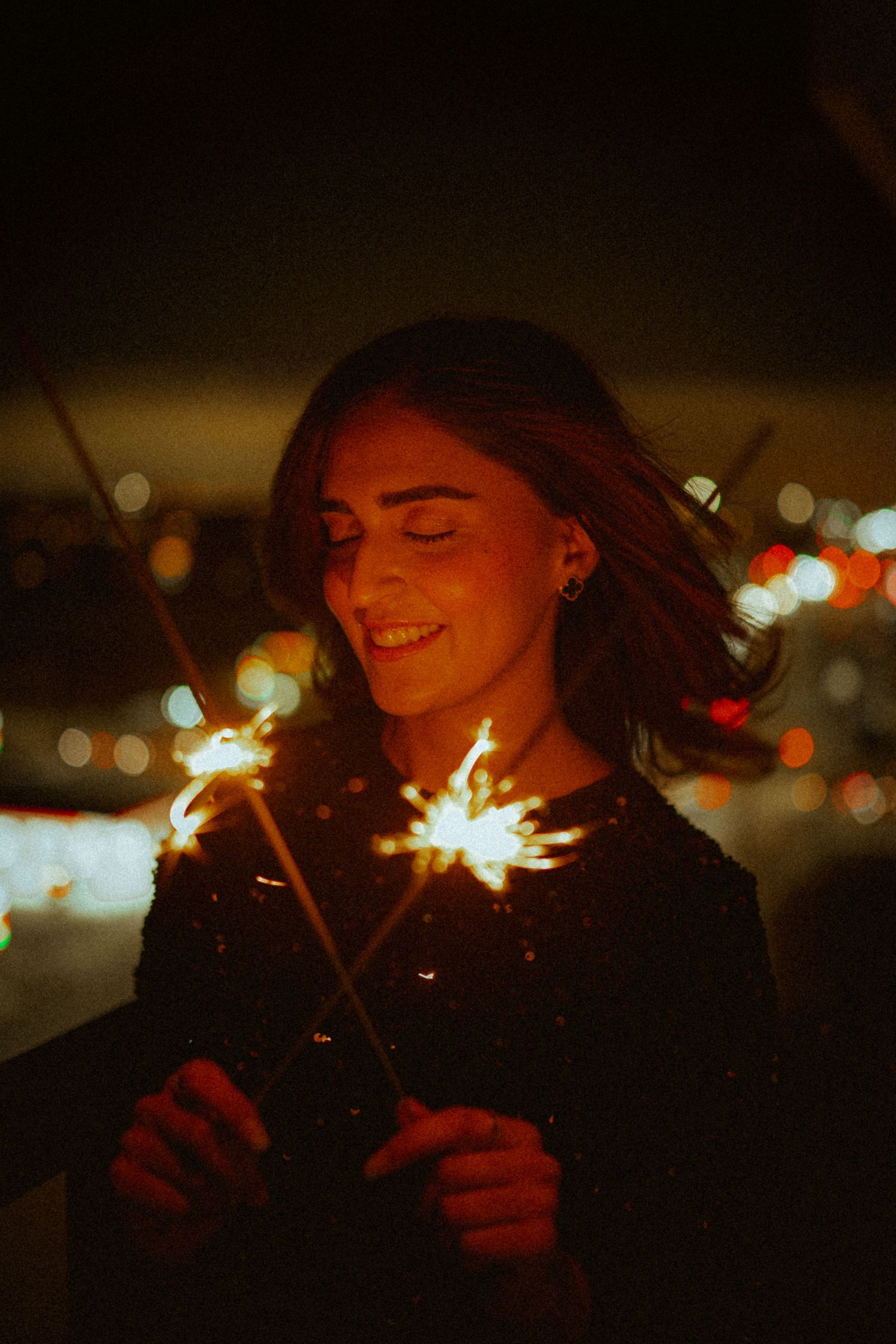 Joyful nighttime portrait series with sparklers creating magical light trails.
