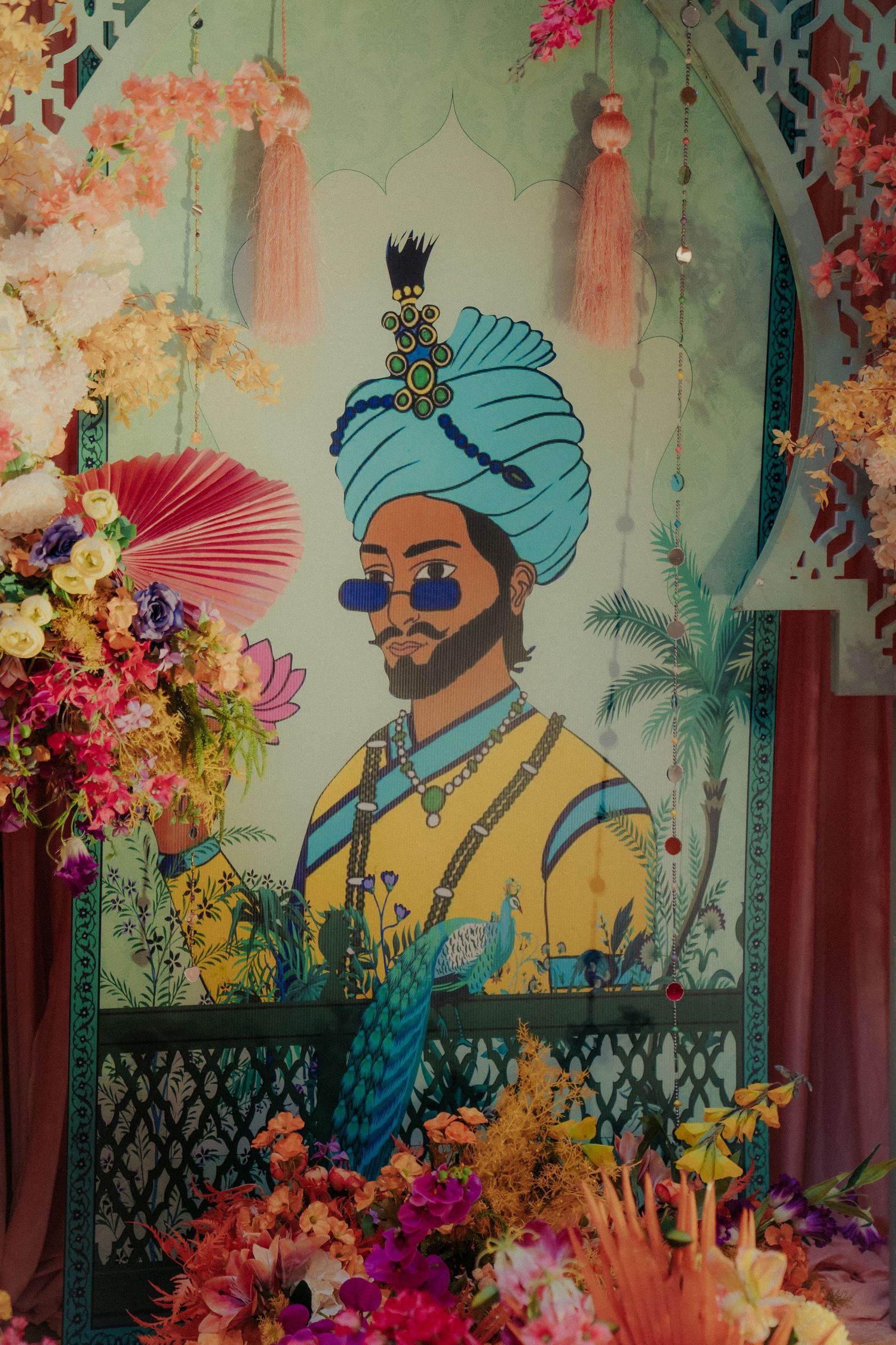 Decorative wall mural showing traditional Indian figures in turquoise and yellow with floral accents.