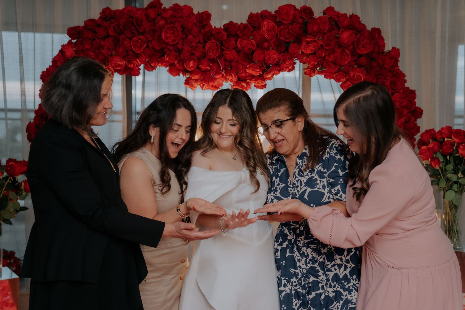 A stunning red rose arch frames an elegant wedding ceremony setup.