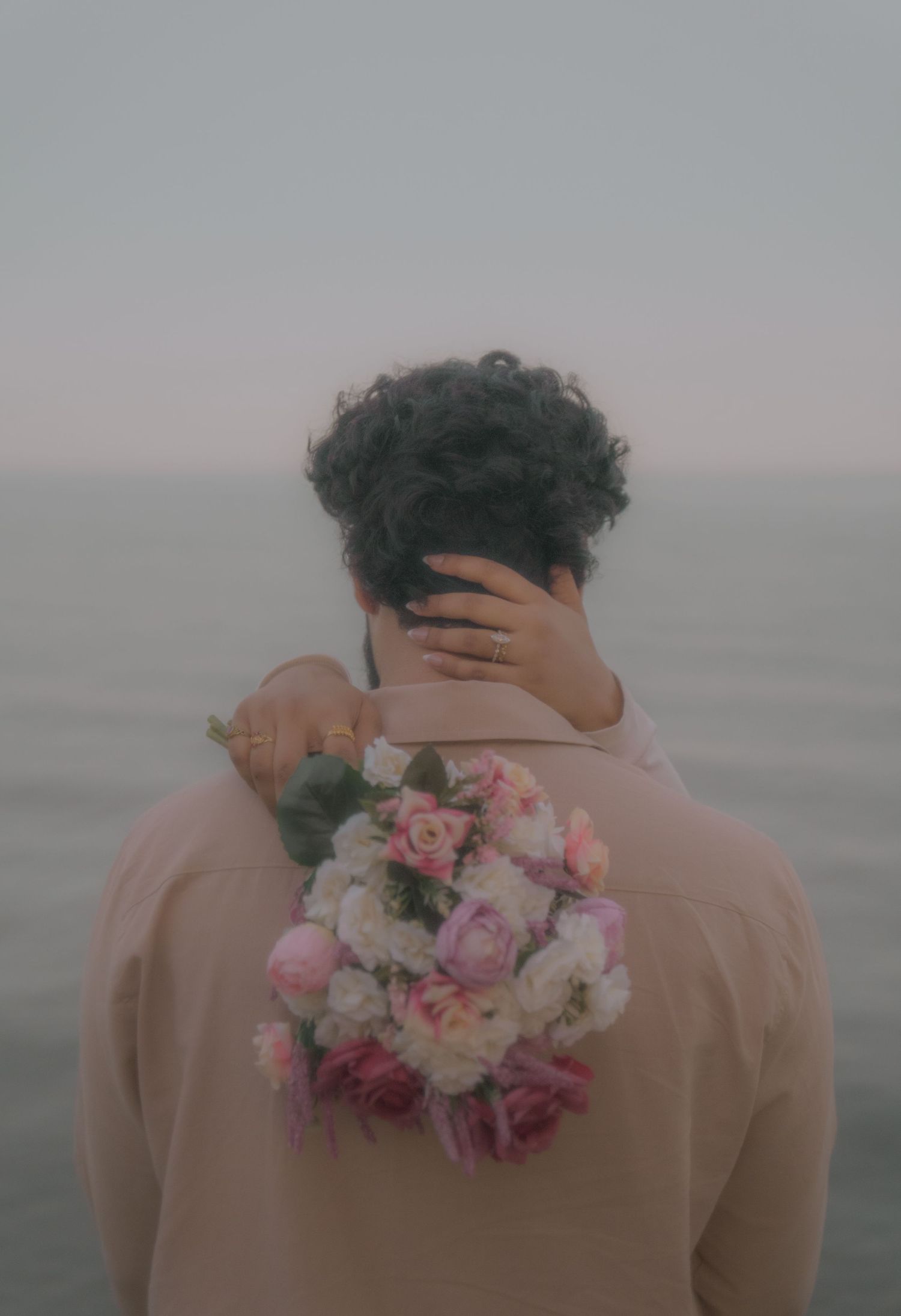 A romantic beach scene with flowers and soft lighting at dusk.