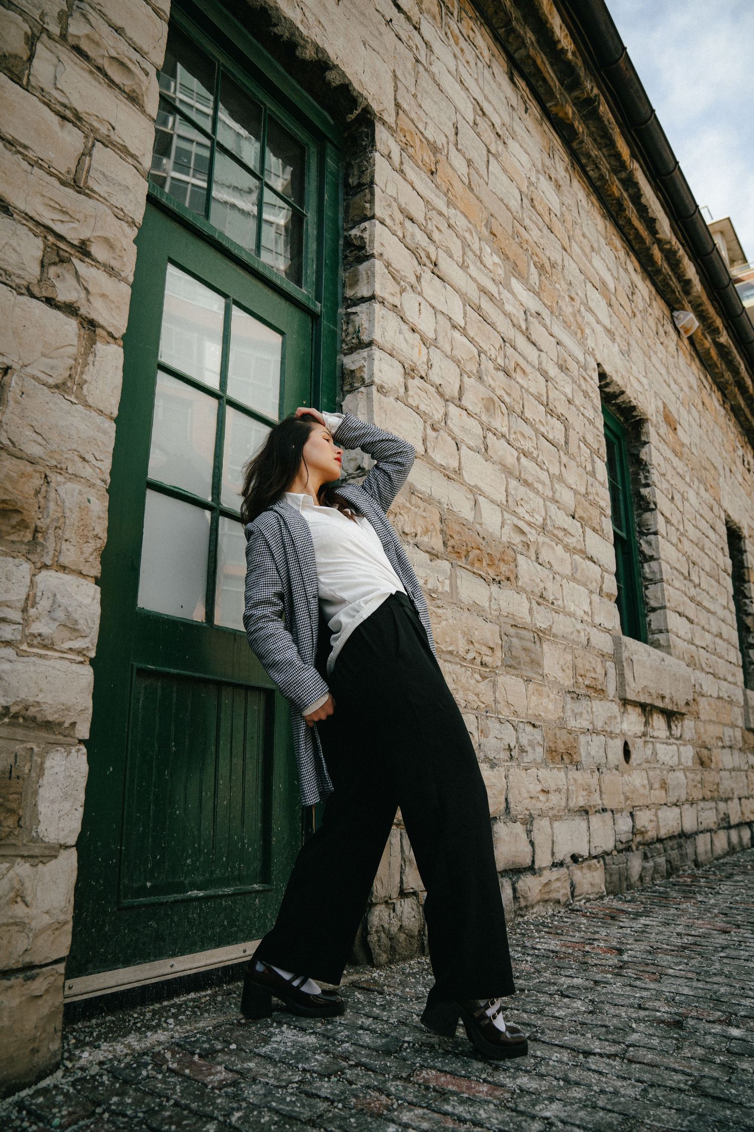 Artistic black and white photos showing dynamic poses against a stone wall.