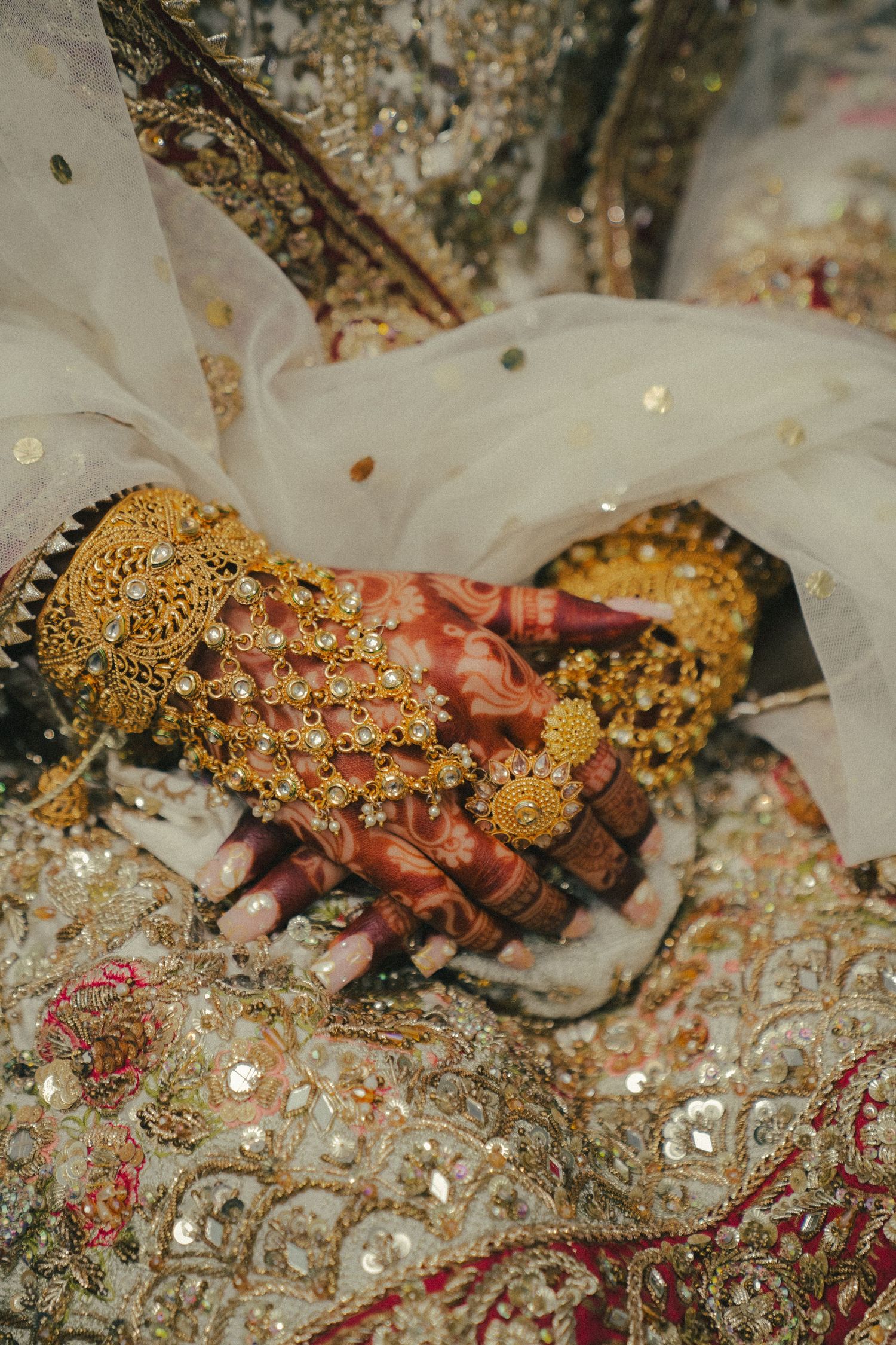 Close-up of ornate golden bridal jewelry with intricate details and gemstones.