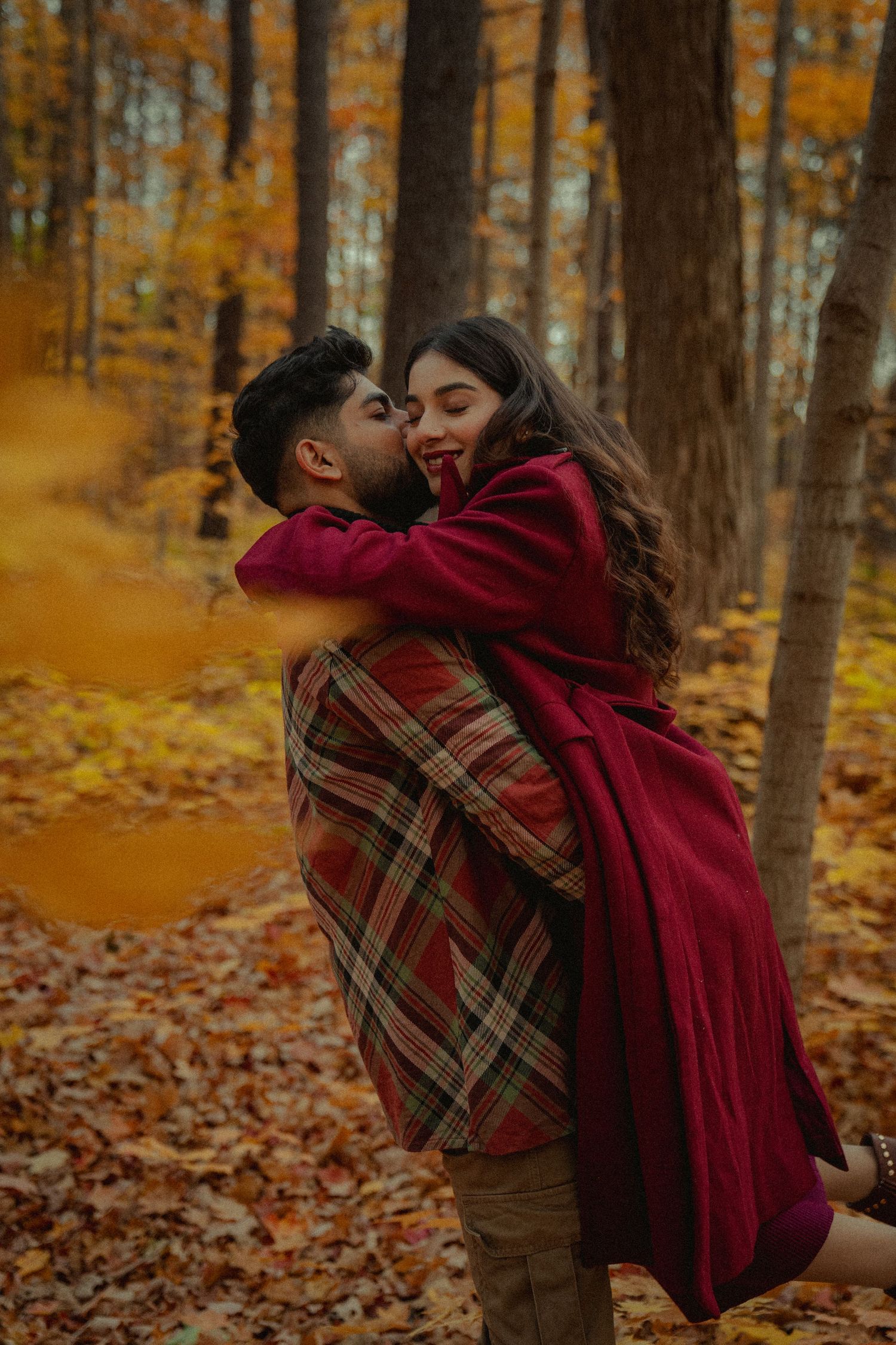 Intimate couple portraits in a forest setting with burgundy and brown autumn clothing.