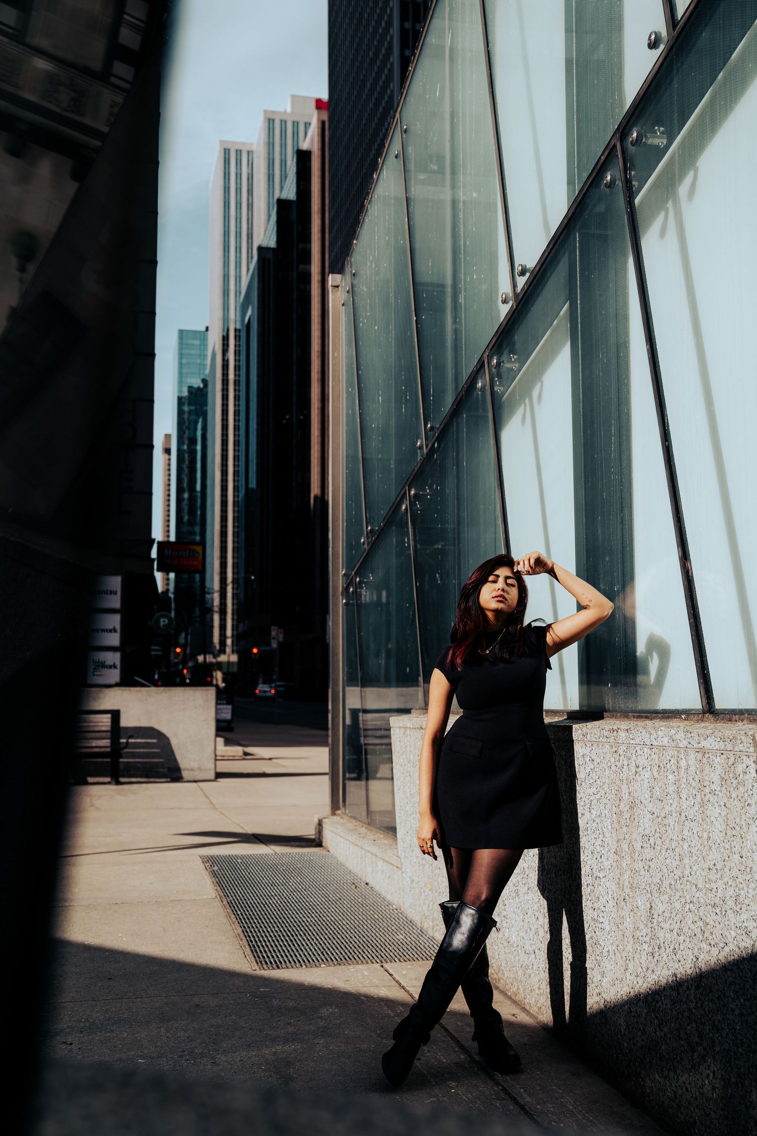 Urban fashion photo with modern architecture and dramatic shadows in downtown setting.