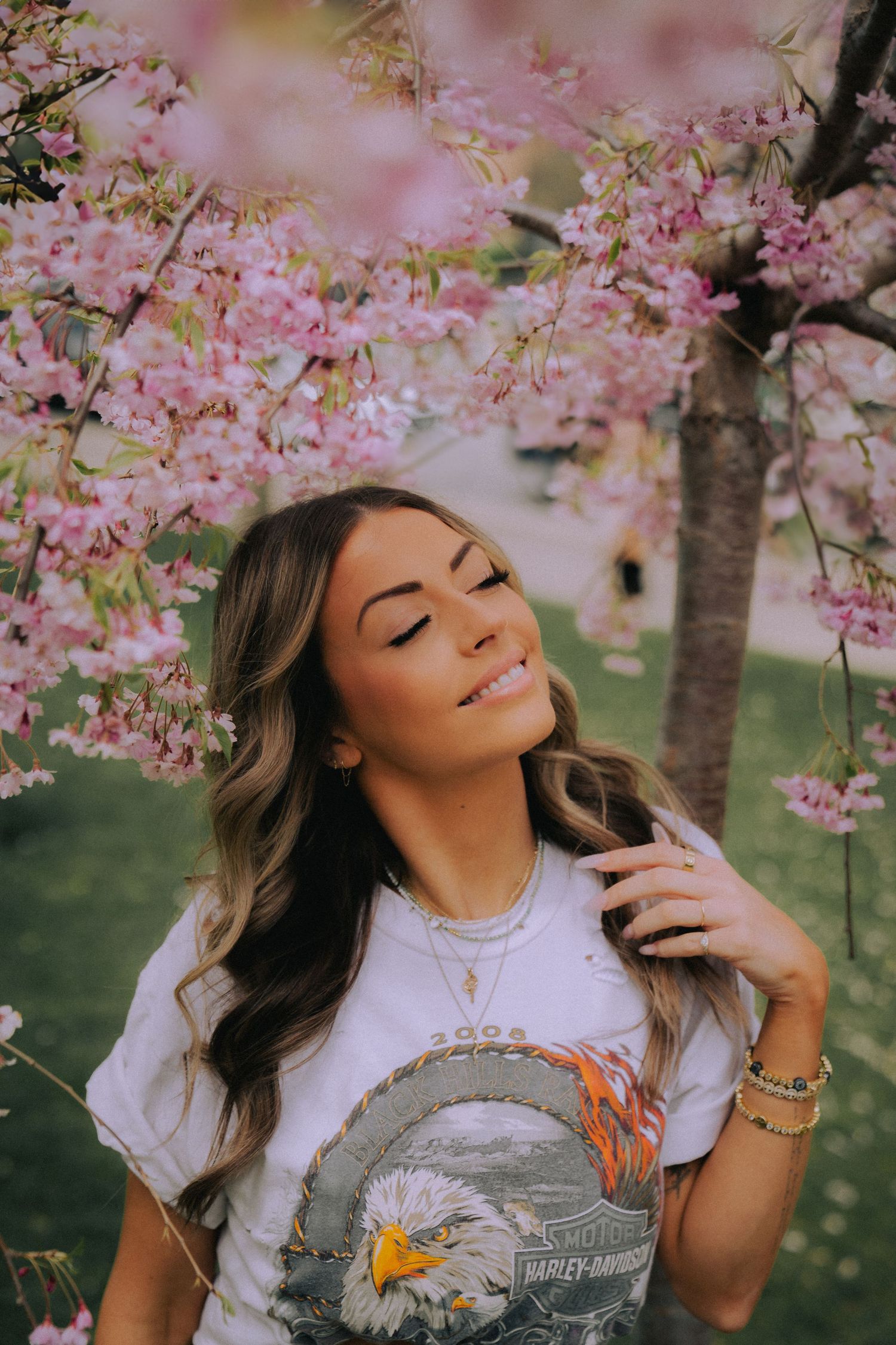 Spring portrait with cherry blossoms featuring a Harley Davidson t-shirt under blooming pink trees.