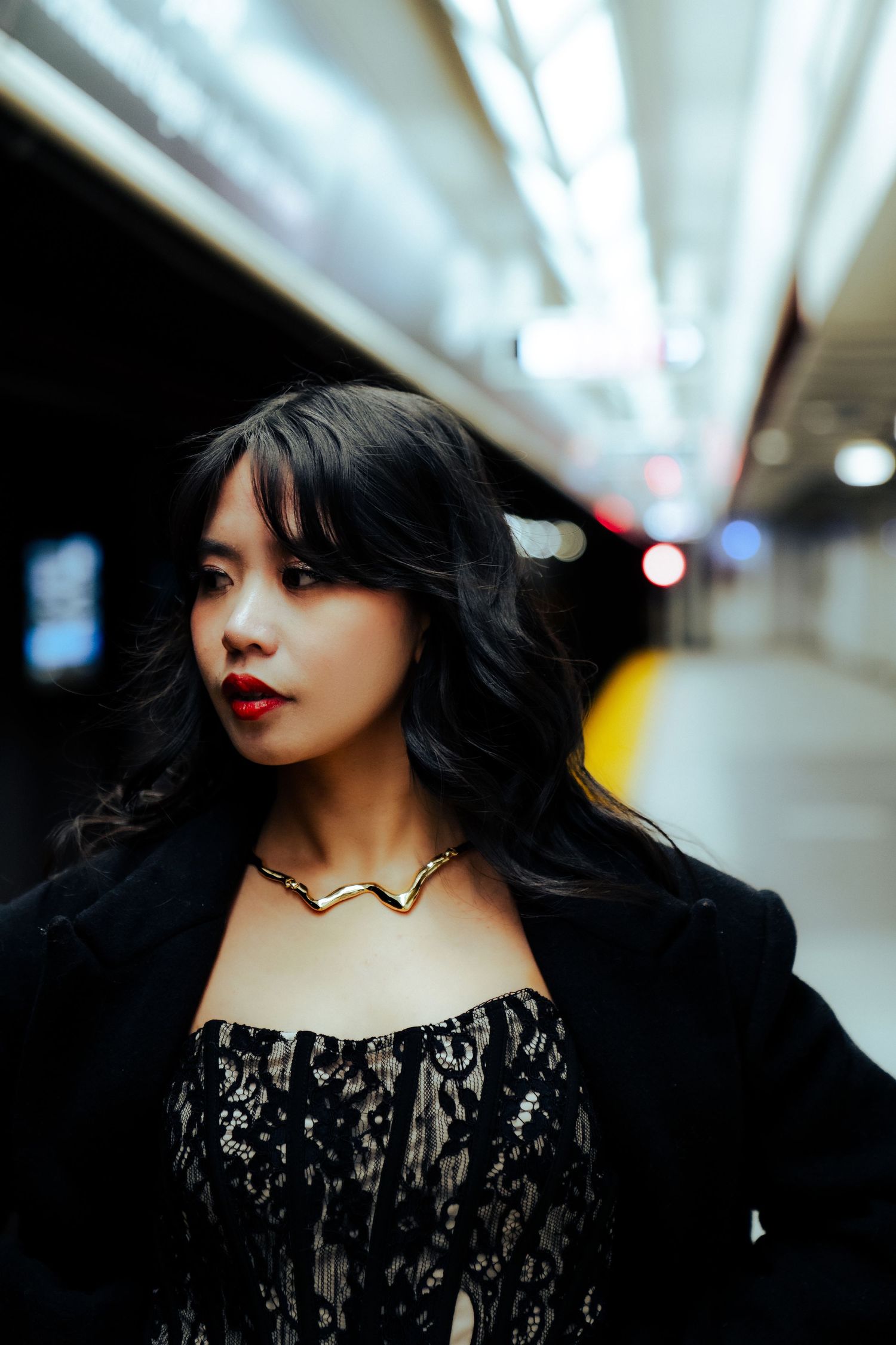 Dramatic portrait sequence in black lace dress with subway lighting.