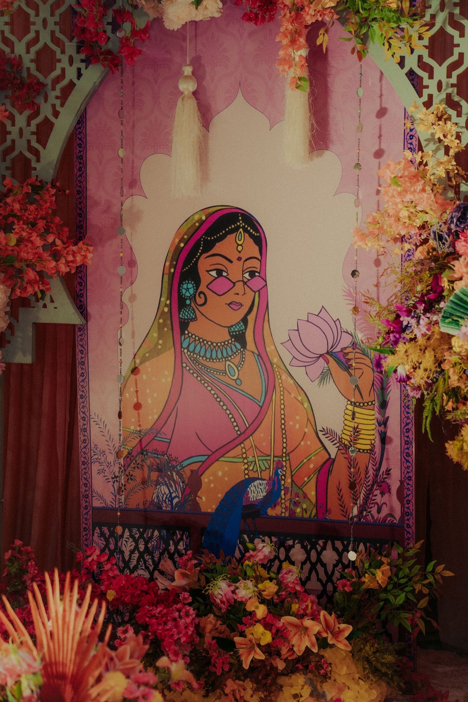 Vibrant wedding decor featuring Indian art murals with colorful floral arrangements and decorative patterns.