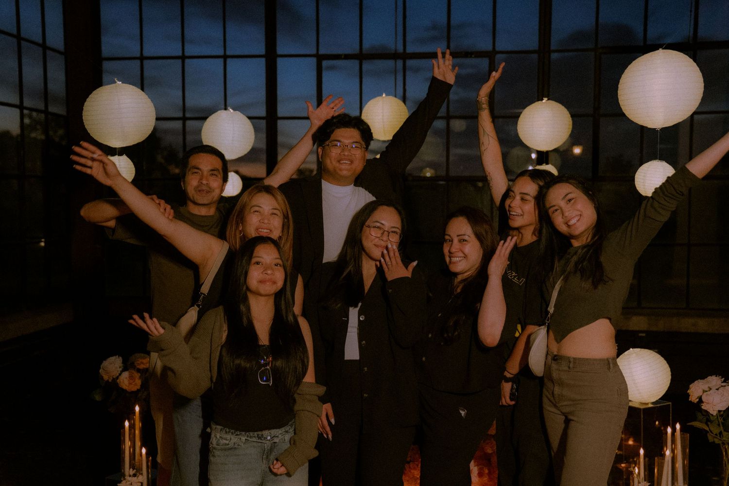 People celebrating at a nighttime event with illuminated paper lanterns creating a festive ambiance.