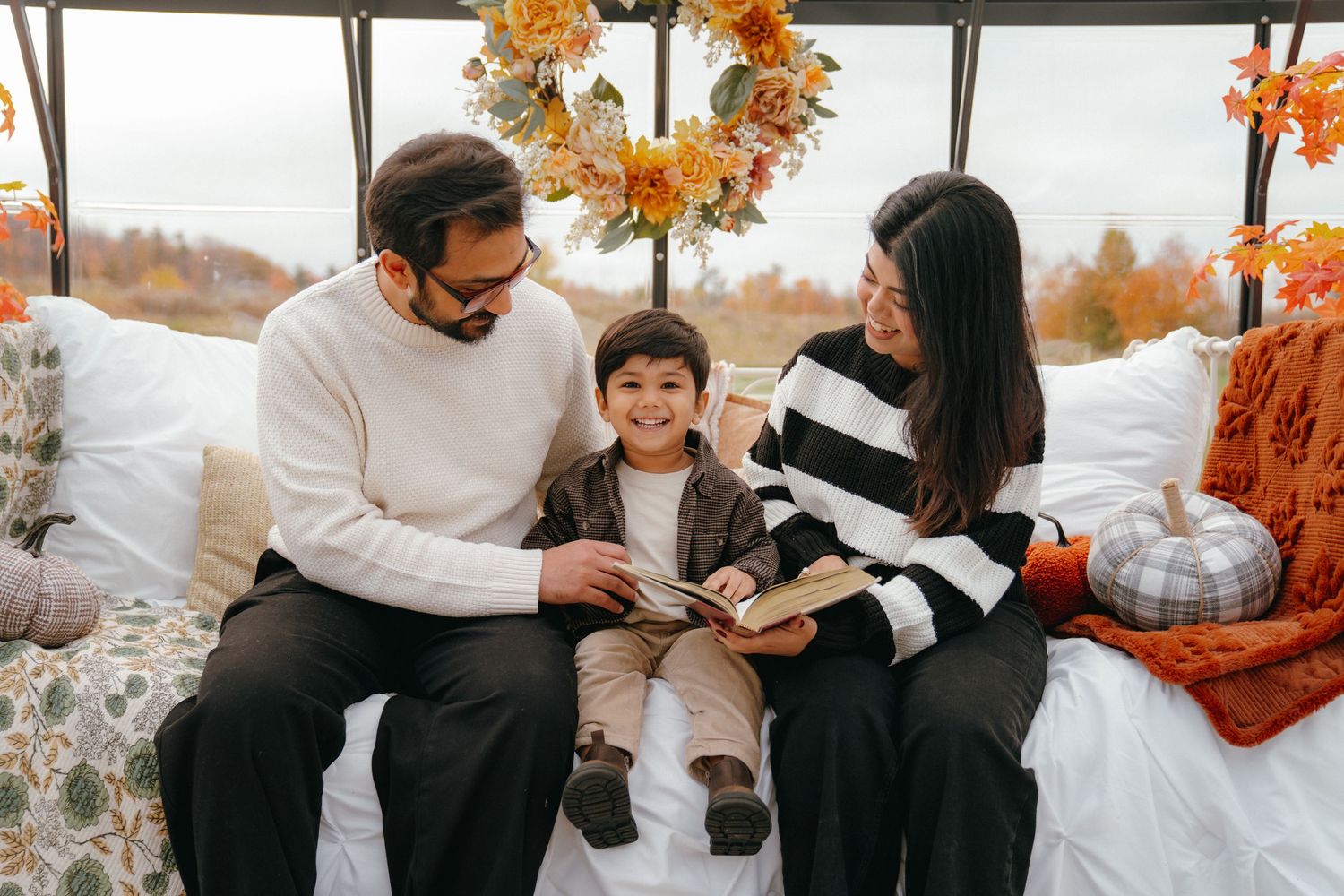 Family sharing playful moments together during autumn photo session.