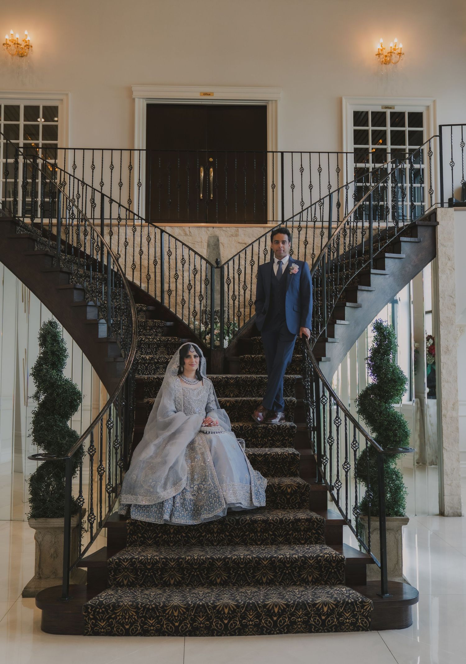 Elegant wedding ceremony setup with white columns and black iron staircase.
