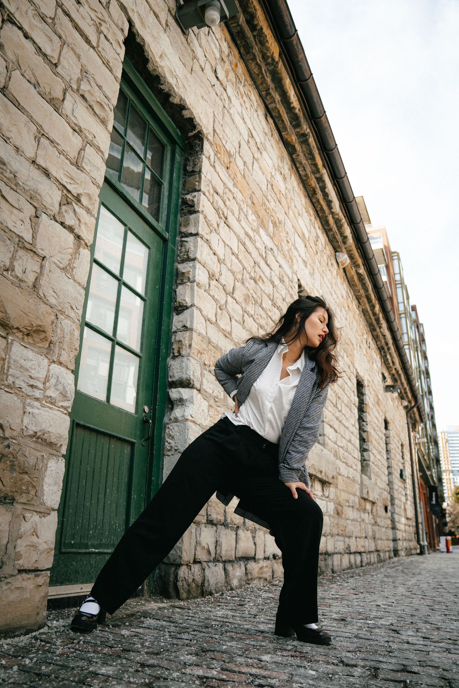 Series of dynamic dance poses captured against a rustic stone wall backdrop.