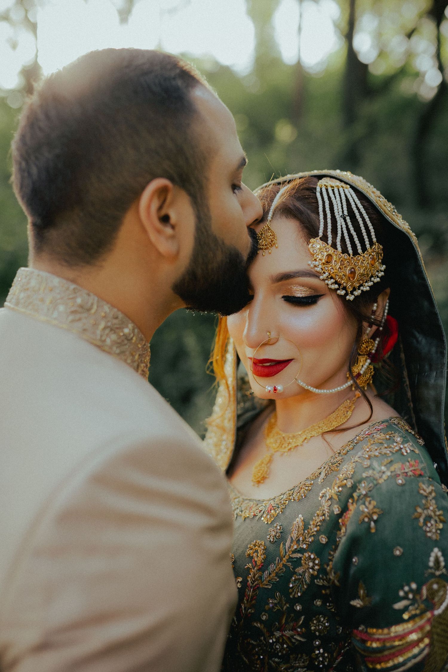 Intimate wedding portrait with traditional South Asian bridal jewelry and makeup.