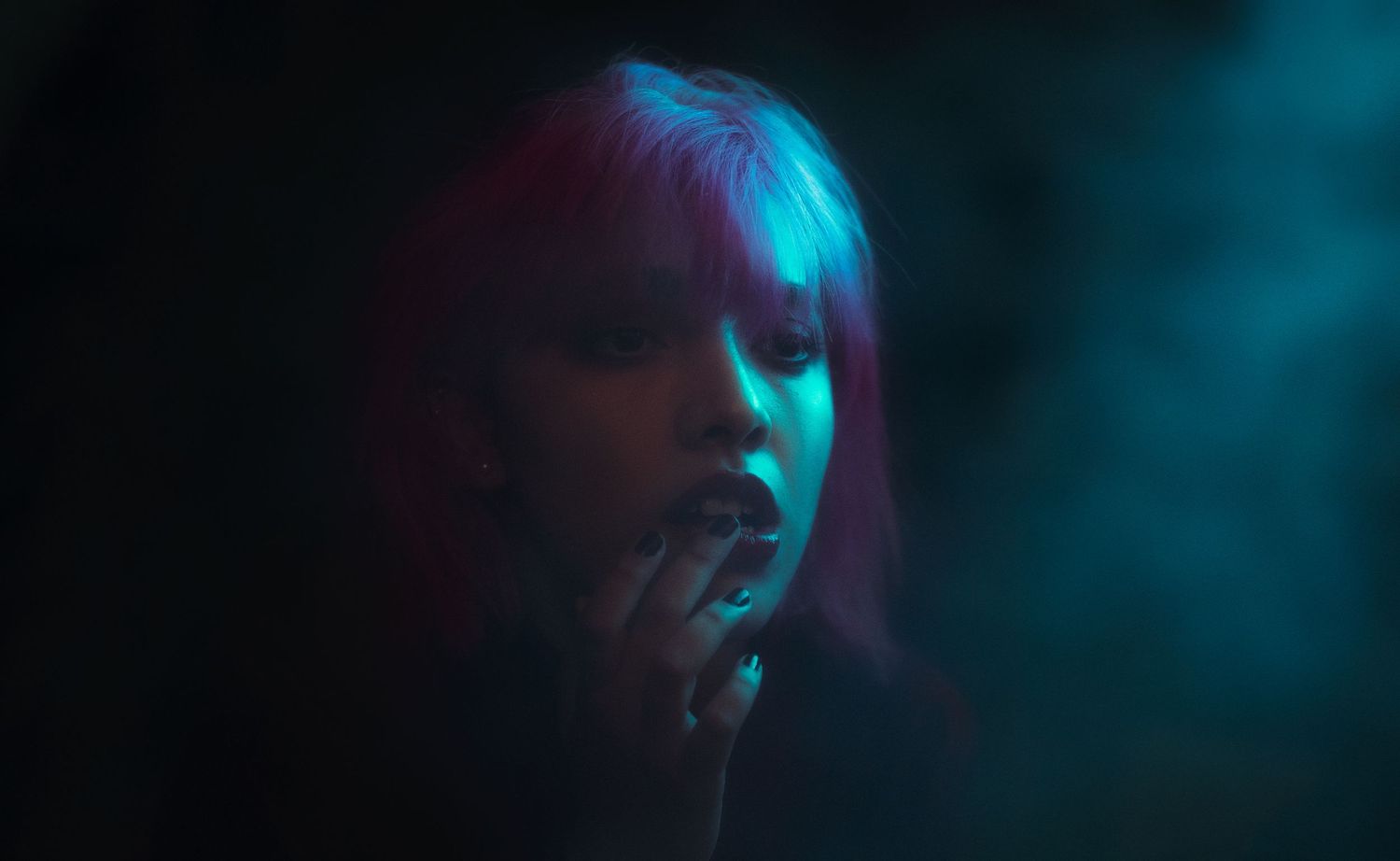 Atmospheric portrait in blue and teal lighting creating a moody nighttime effect.