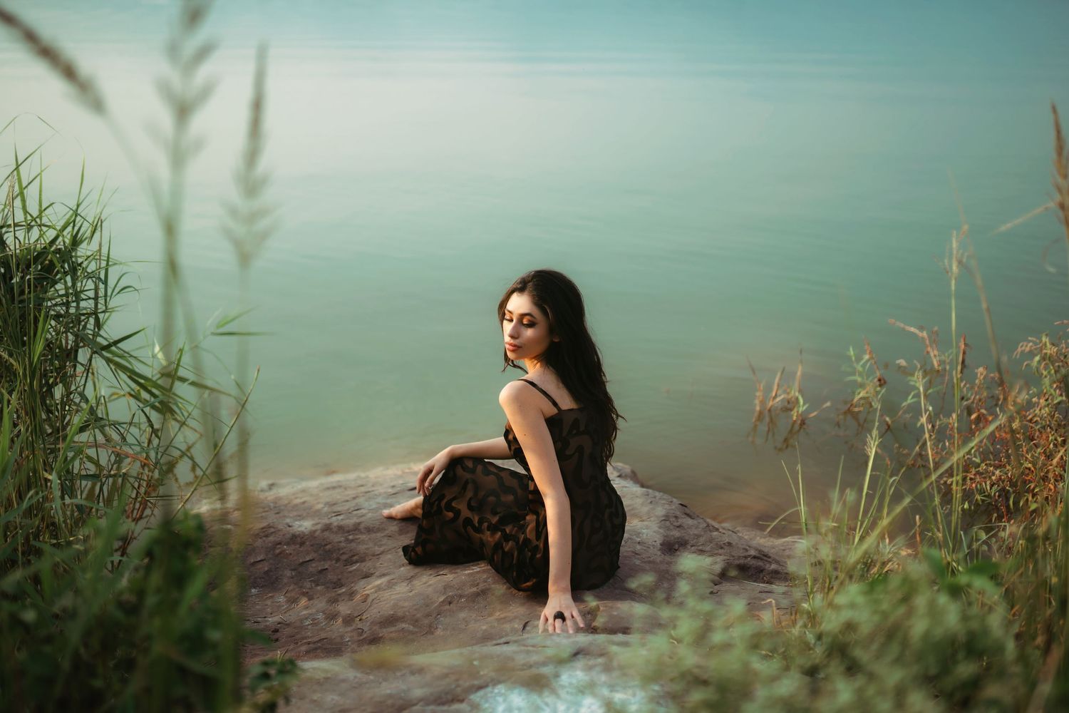 Serene lakeside portrait series with teal water and natural grass in background.