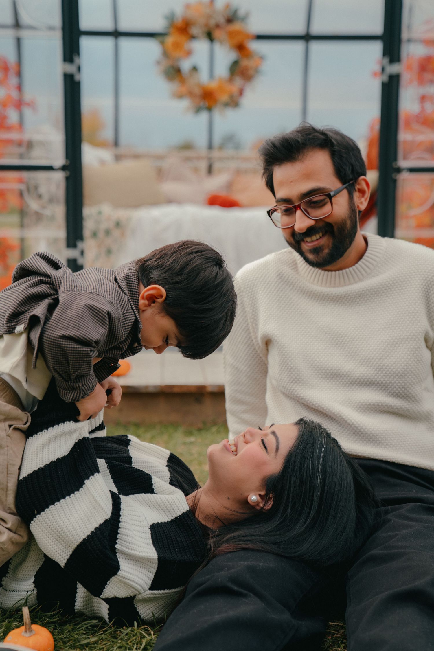 Candid family moments captured in autumn setting with warm sweaters.