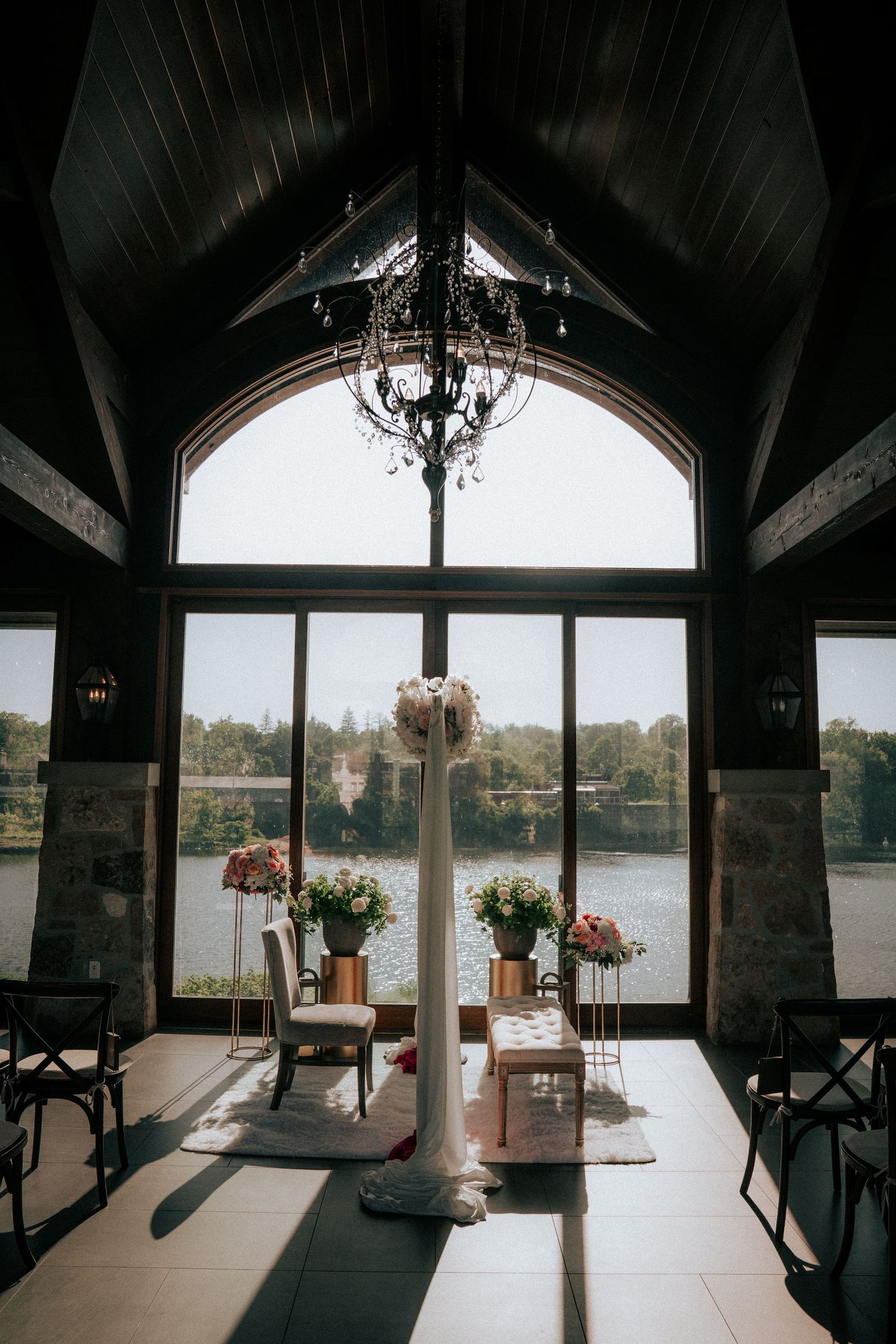 Rustic lakeside venue interior with vaulted ceiling and panoramic water views.