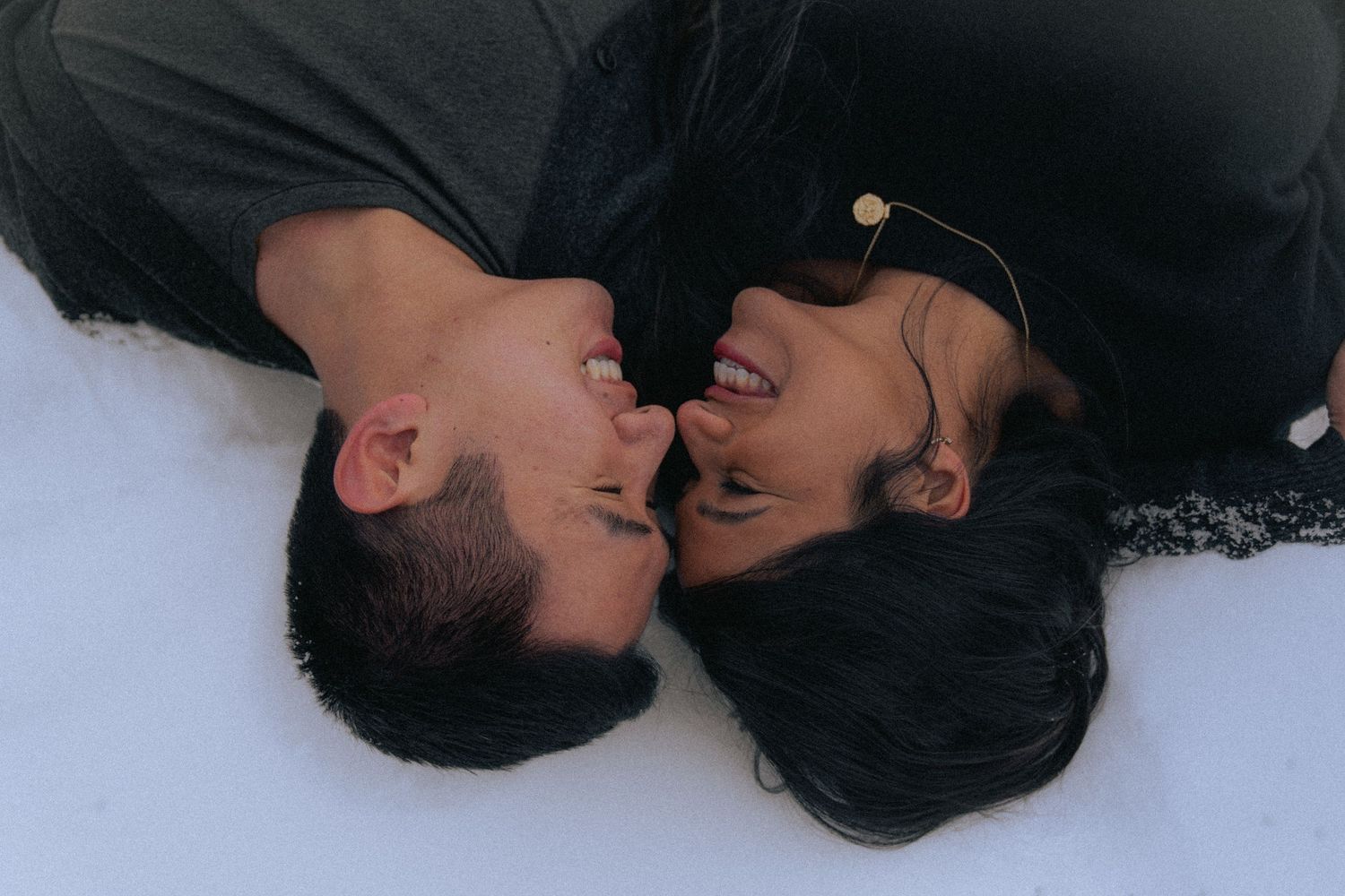 Artistic black and white portrait showing two people lying down with dark hair.