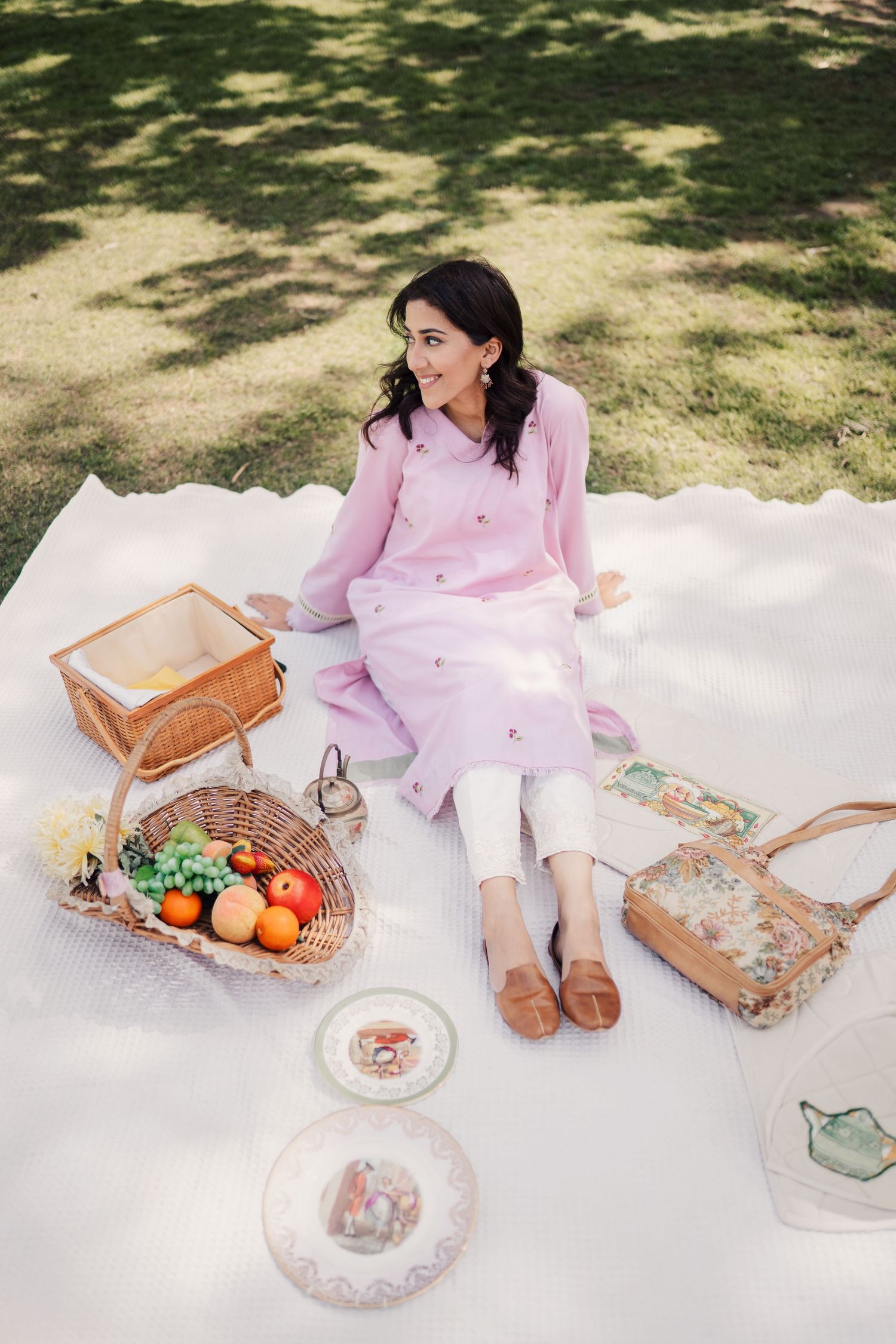Outdoor picnic scene with pink outfit and vintage-style food arrangements.