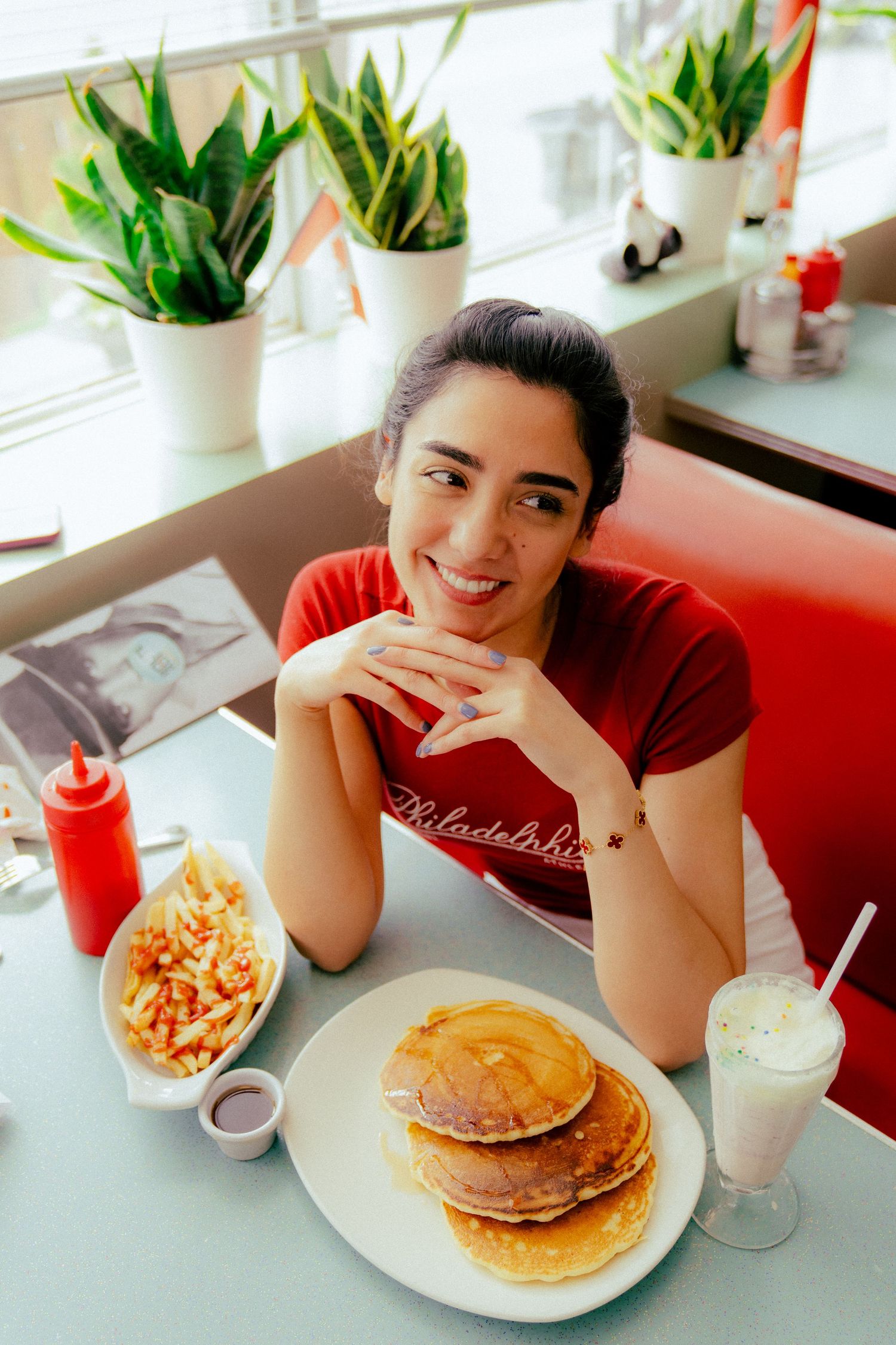 A series of diner photos showing pancakes and breakfast food on white plates against a red counter.