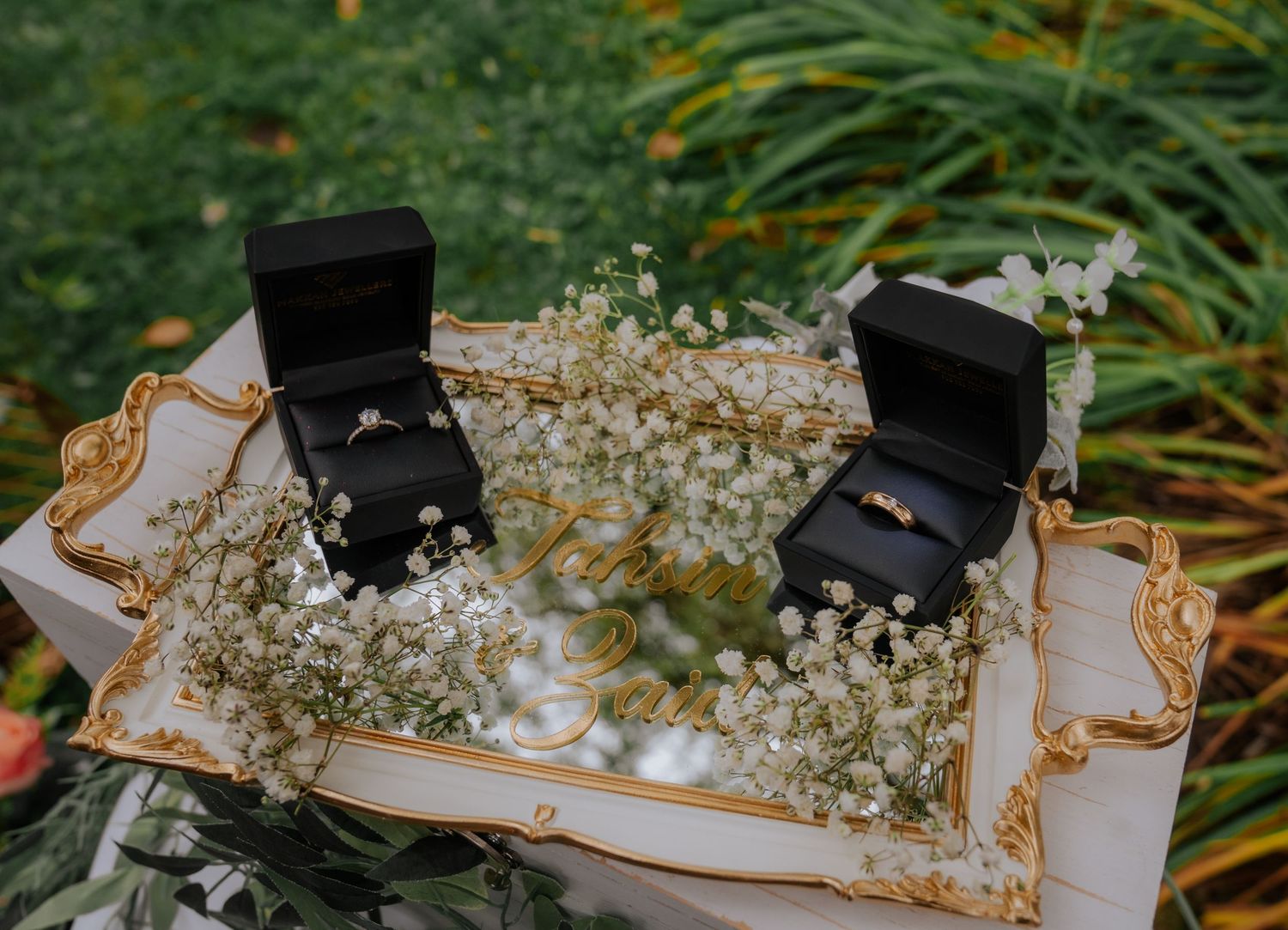 White sneakers decorated with delicate baby's breath flowers against a green garden background.