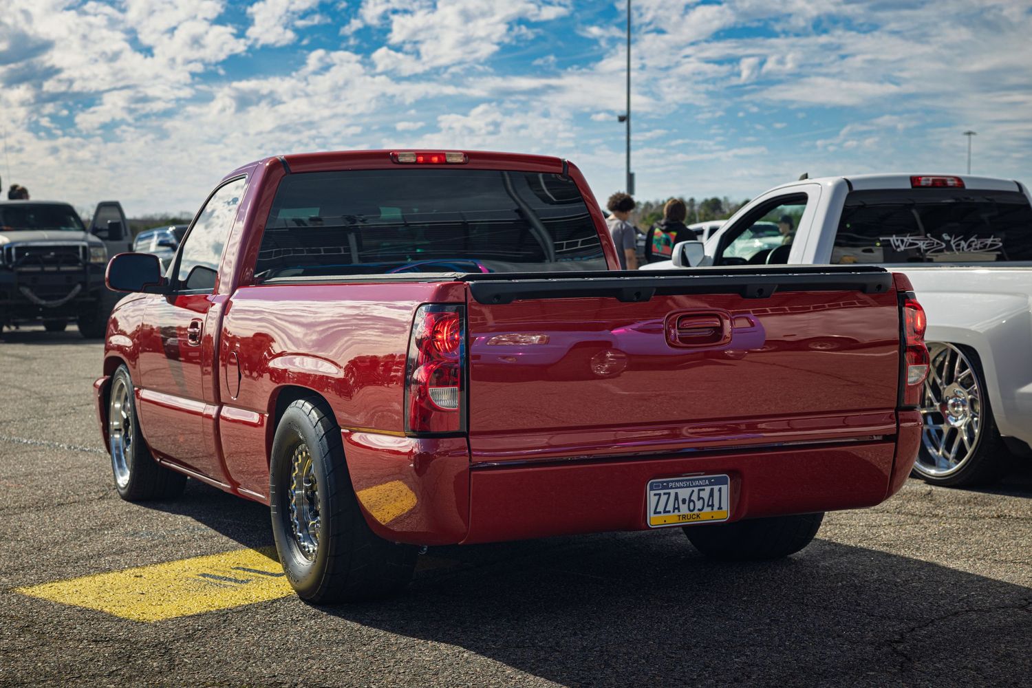A red classic Chevrolet custom lowrider pickup truck shown from multiple angles at a car show.