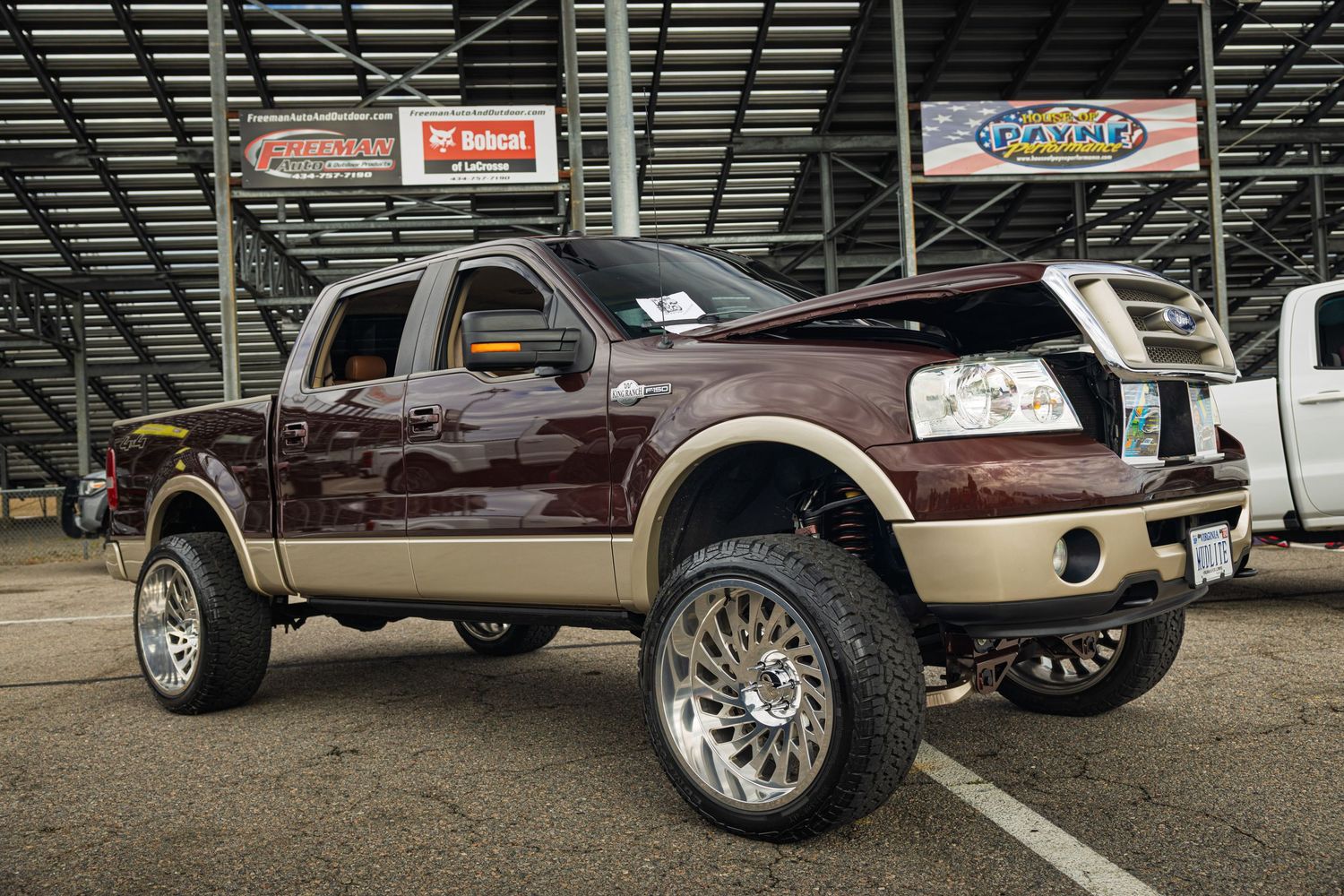 Custom chrome wheels and lifted suspension on a modified truck showcase aftermarket automotive customization details.