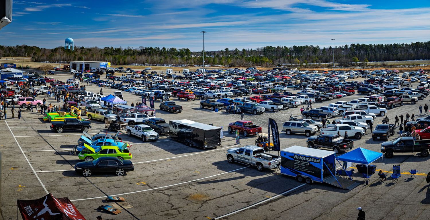 Aerial panoramic view of Frostbite 5 2025 at VMP parking lot filled with rows of vehicles under bright blue skies.
