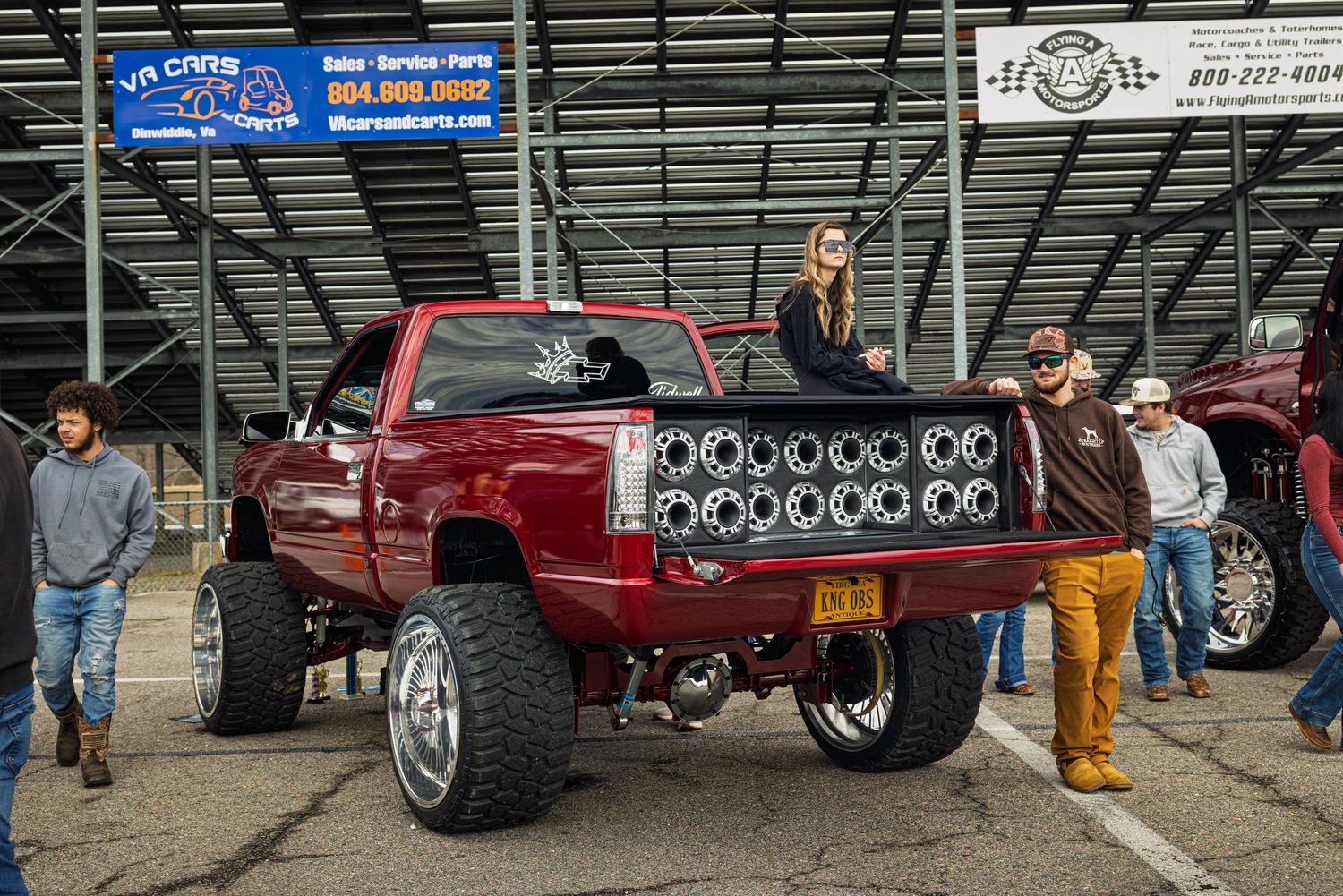 Custom pickup trucks with large chrome wheels and lowered suspensions displayed at a car show.