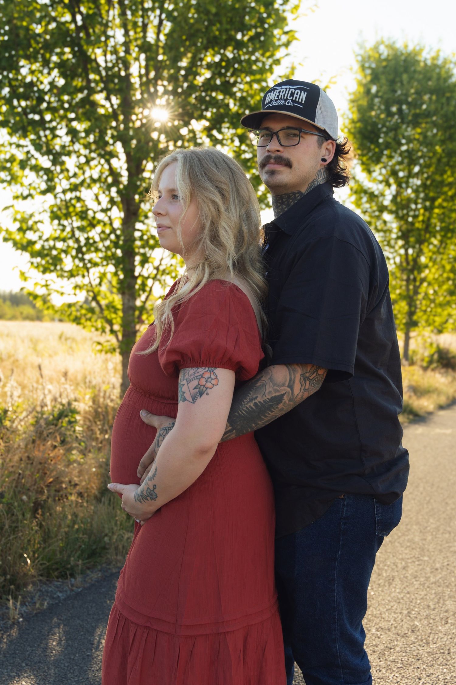 A couple shares a tender moment on a path during golden hour.