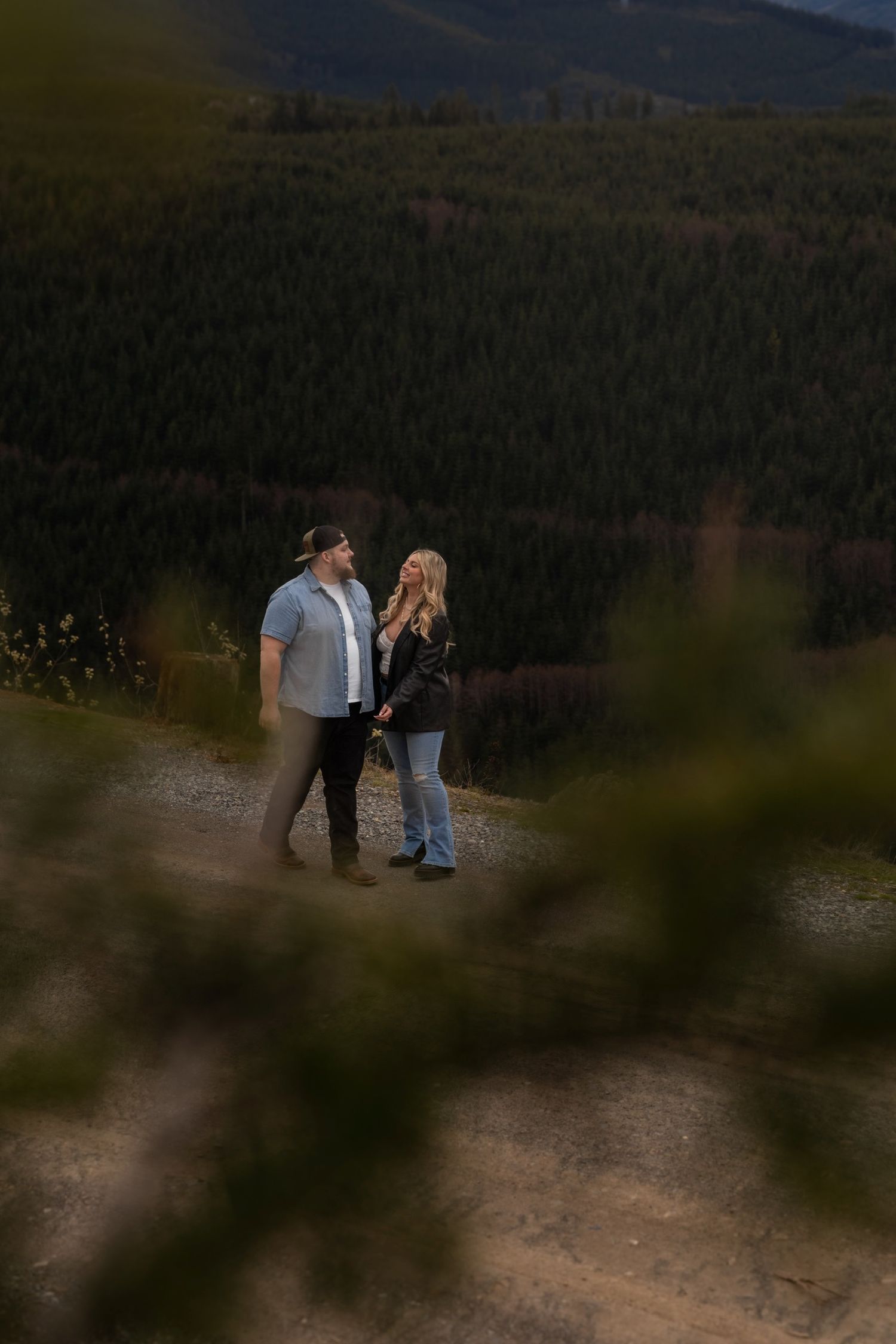 Silhouettes of people gathered on mountain overlook at dusk.