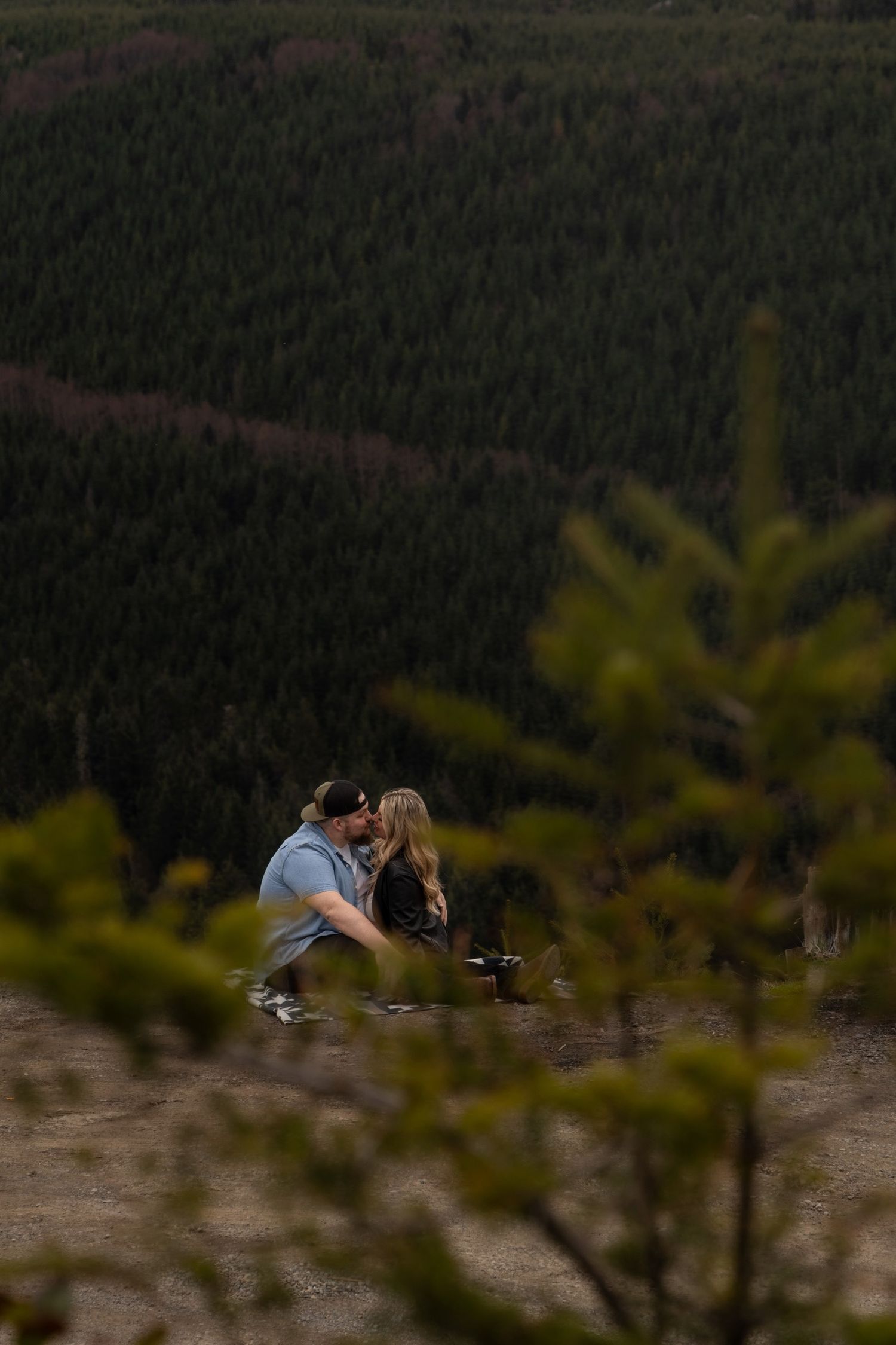 A romantic mountain engagement session with pine trees in the foreground.