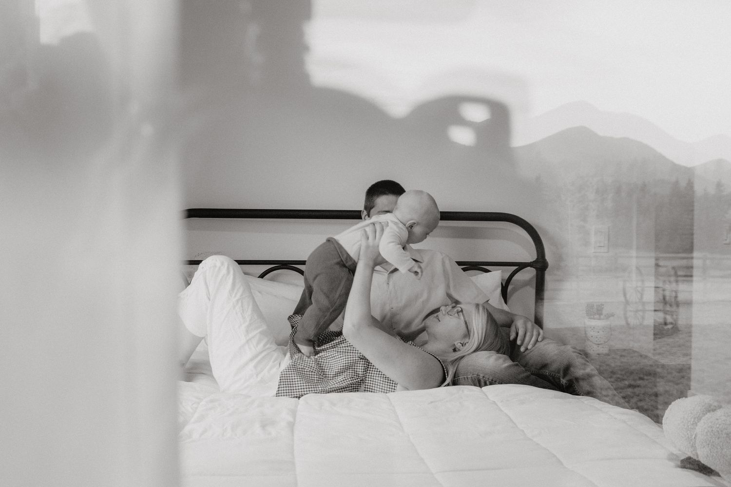 Black and white photo series showing tender moments between a couple cuddling and embracing in bed.