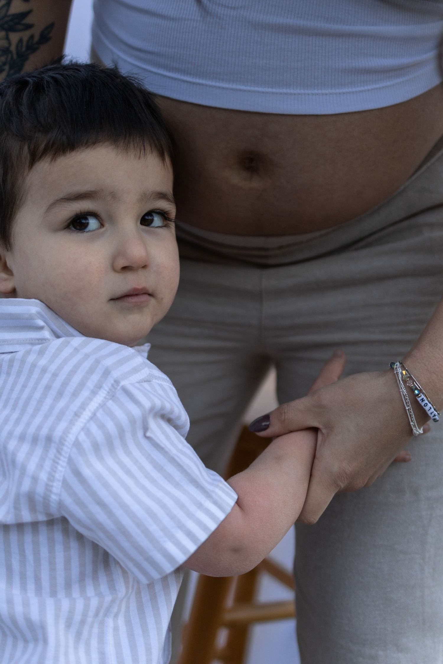 A close-up shot showing a gentle touch against a maternity backdrop.