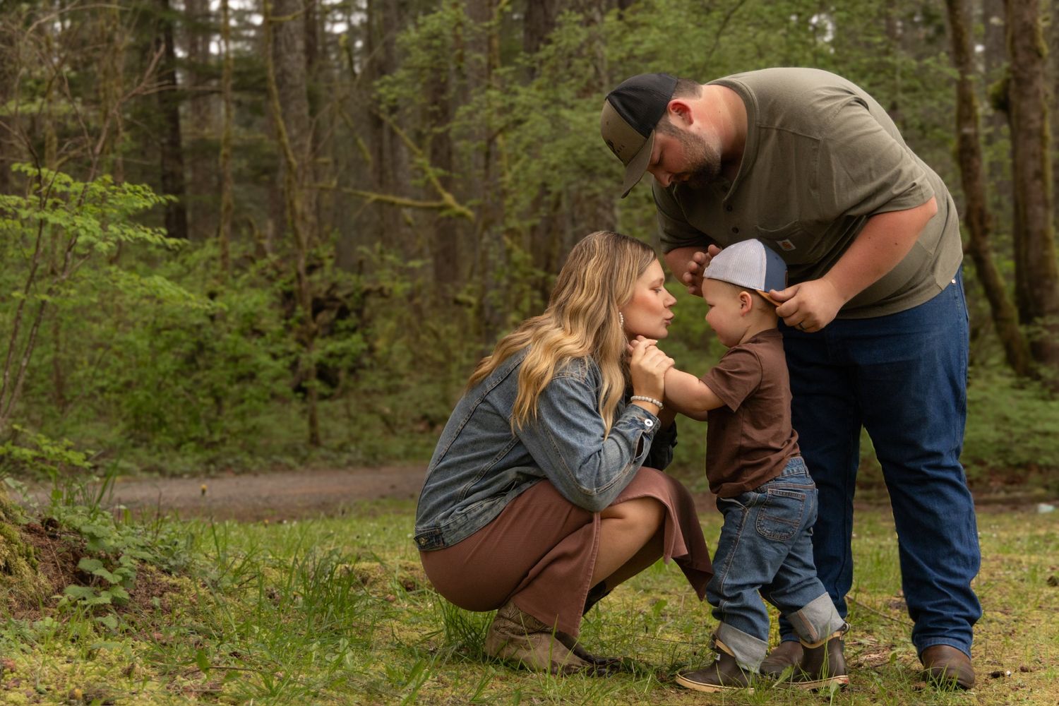 A candid family moment shared while playing together on a forest trail.