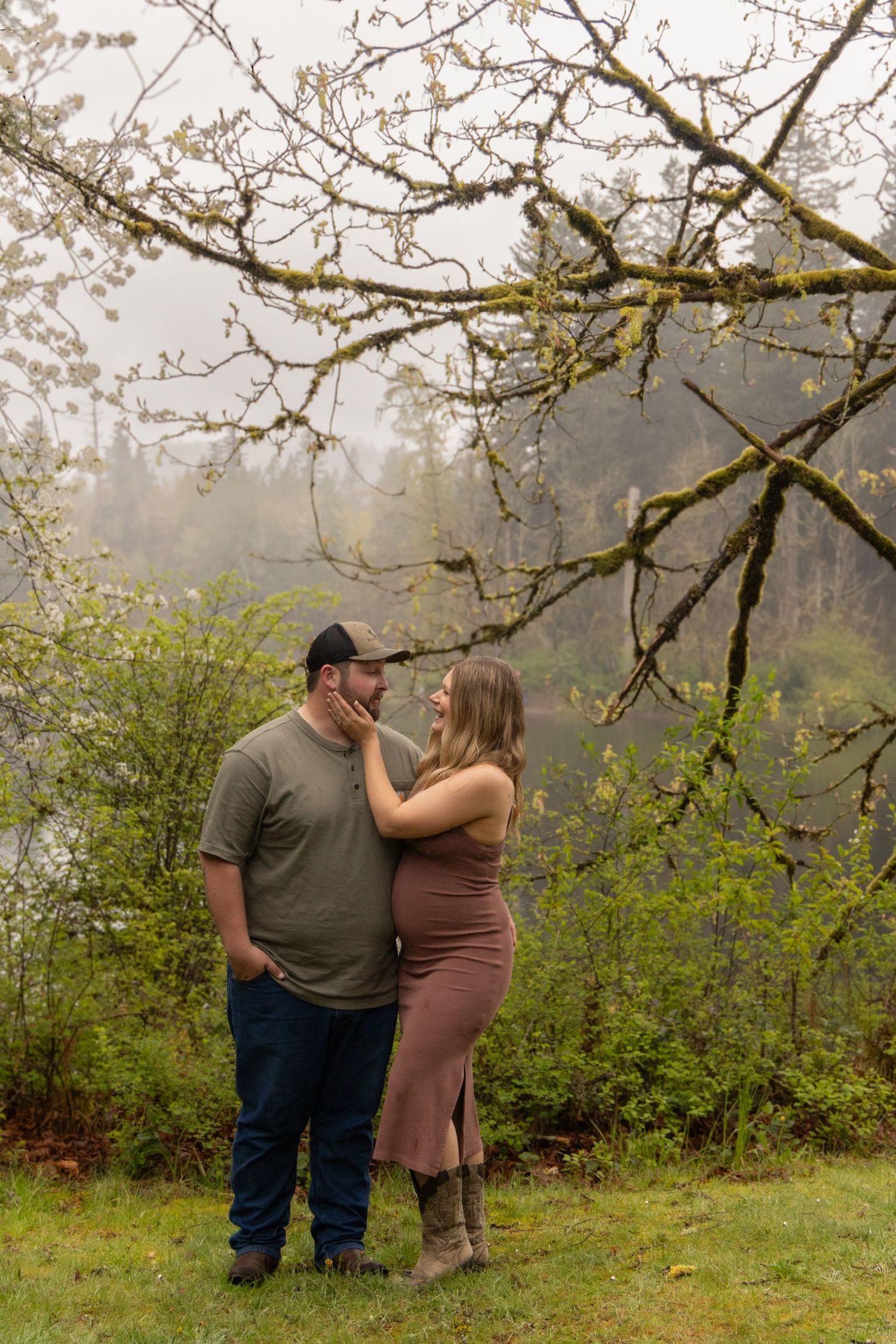 Couple shares tender moment during outdoor maternity session.