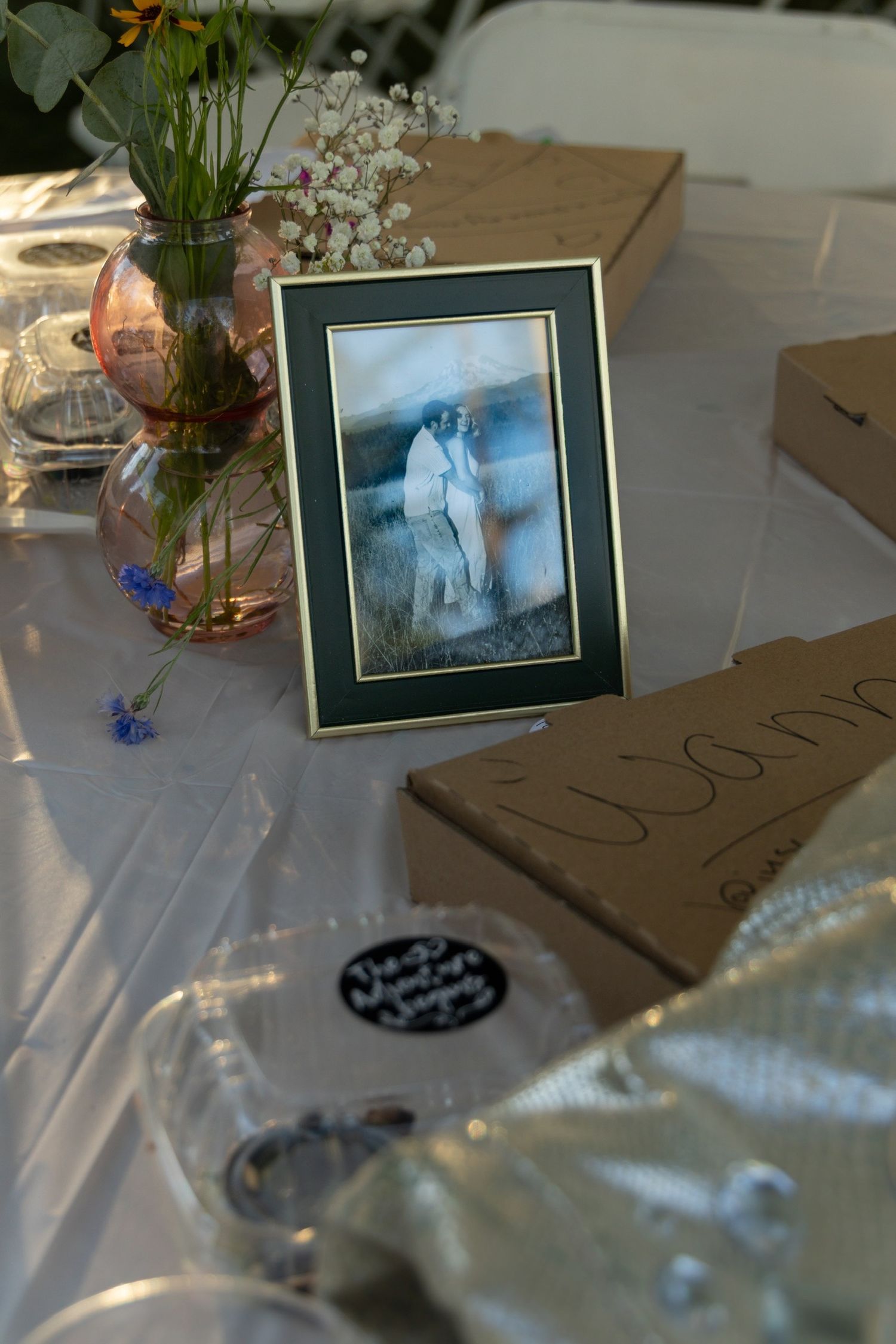 Wedding reception table details with framed photos and floral arrangements.