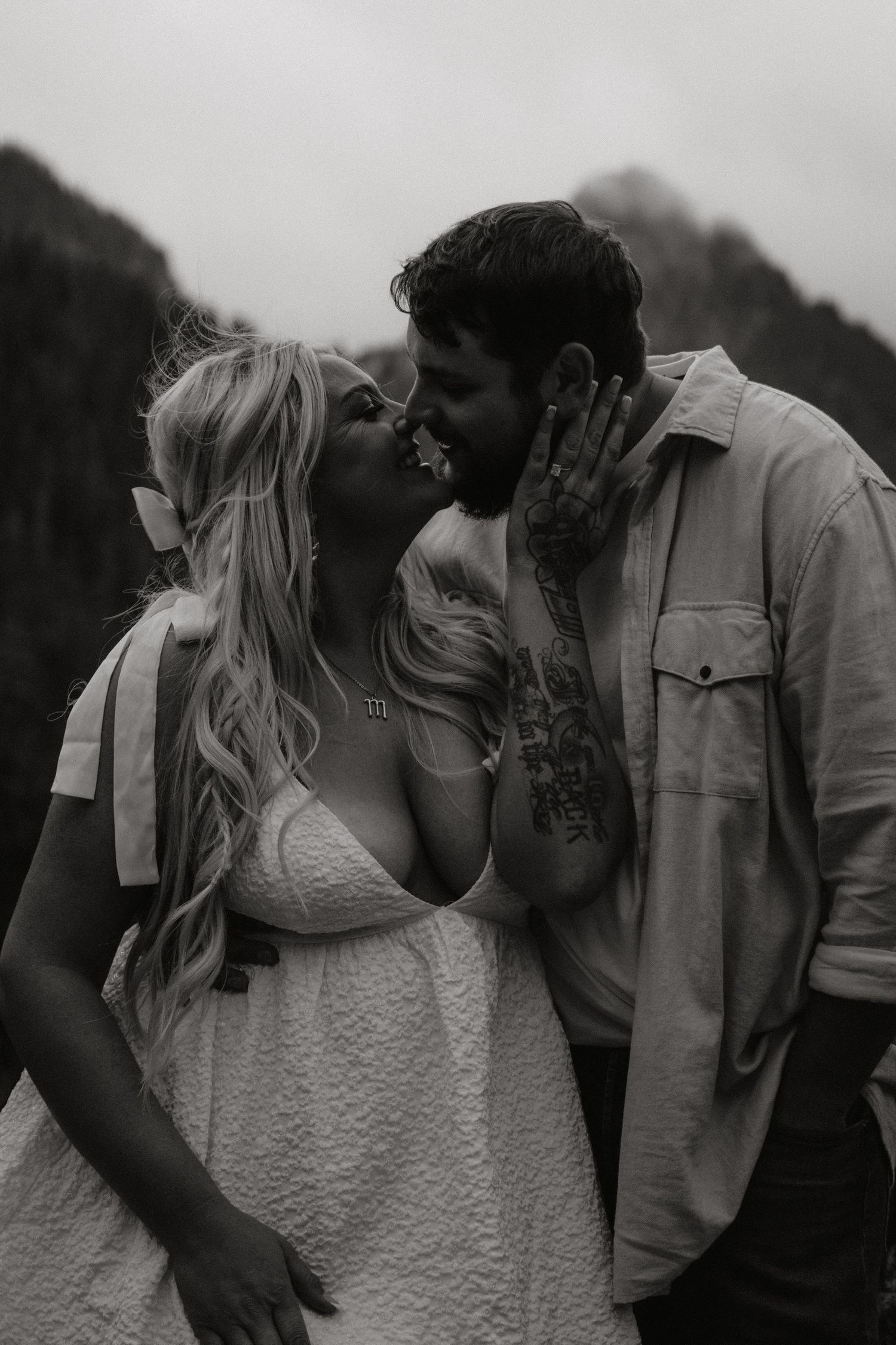 An intimate black and white moment shared between a couple during an outdoor photoshoot.
