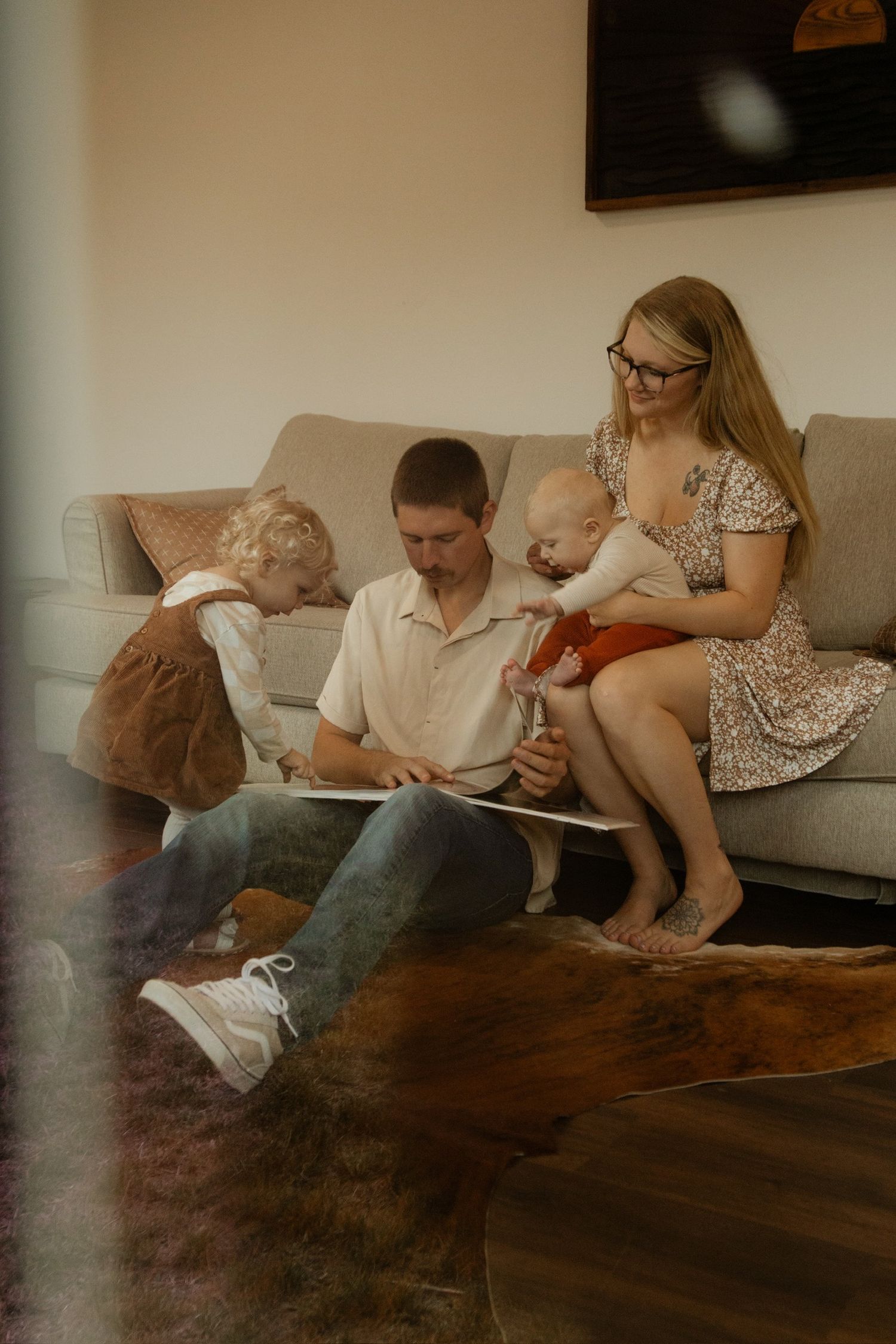 A cozy family scene on a living room couch sharing a quiet moment together.
