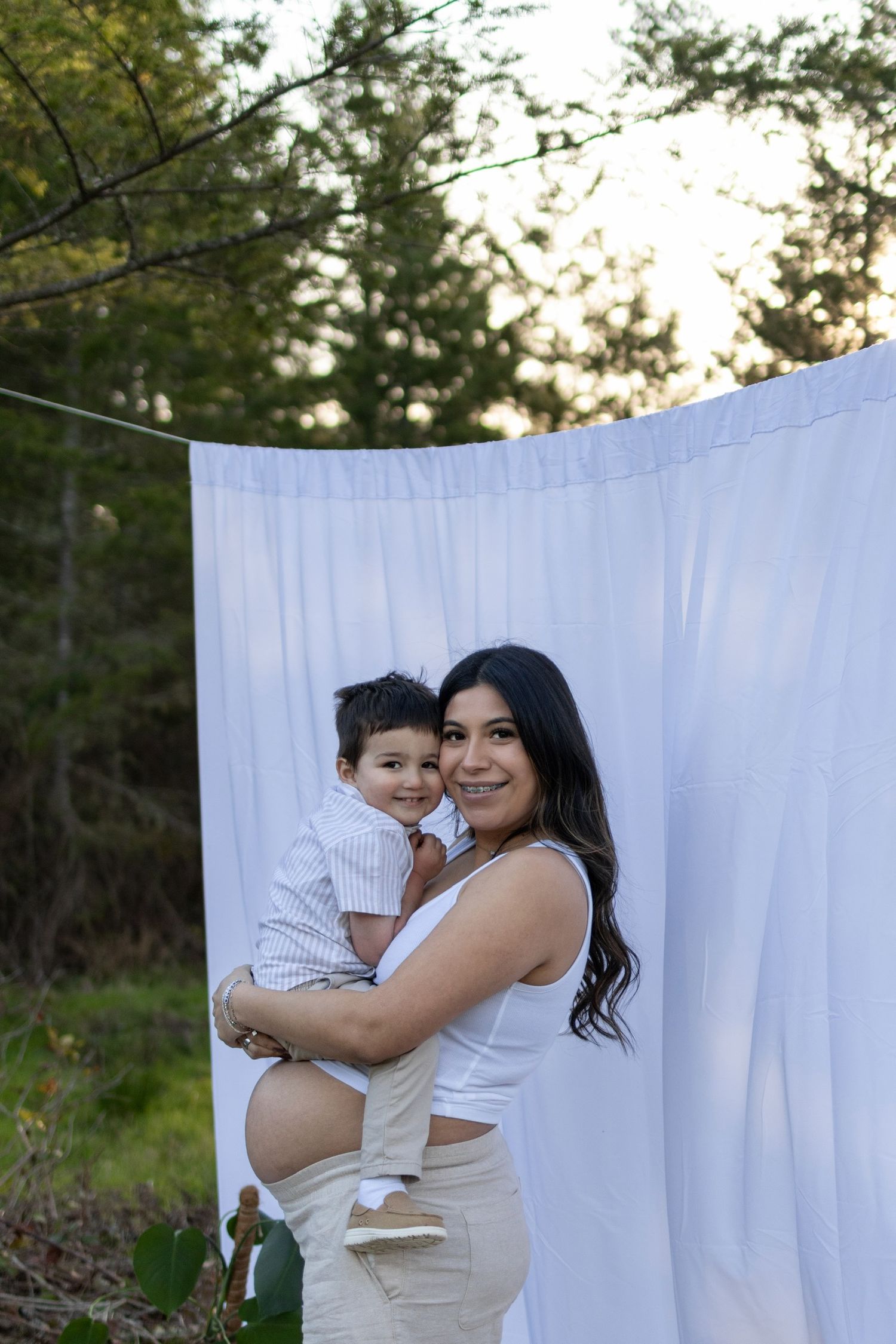 A series of outdoor family portraits against a white backdrop with trees and natural lighting at sunset.